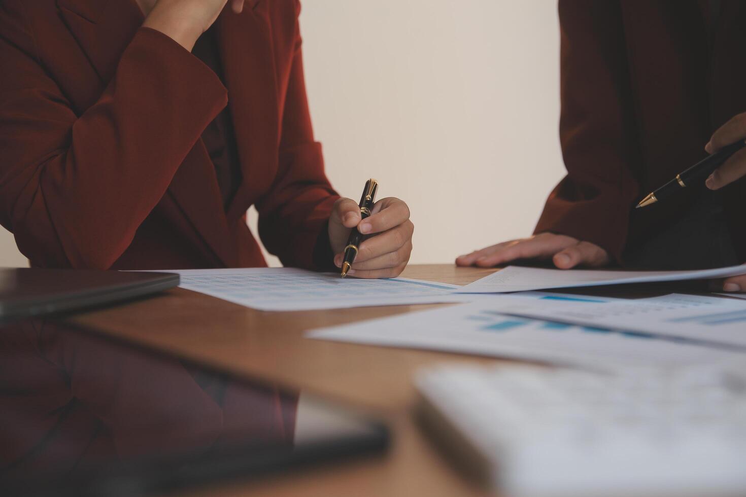Group of confident business people point to graphs and charts to analyze market data, balance sheet, account, net profit to plan new sales strategies to increase production capacity. photo