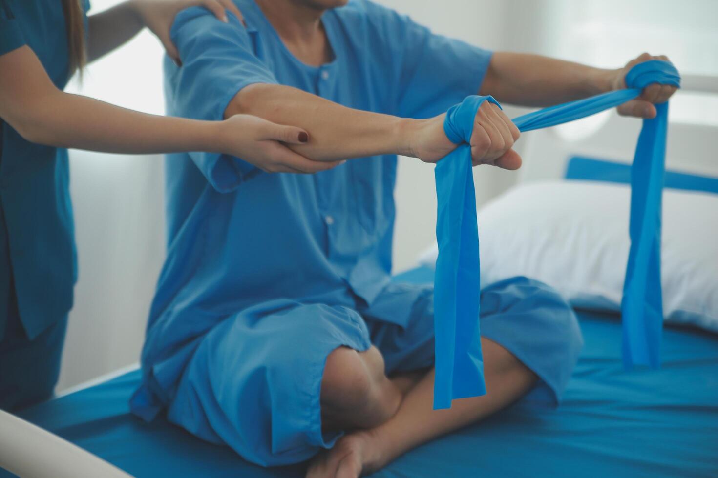 Close up hand patient doing stretching exercise with a flexible exercise band and a physical therapist hand to help in clinic room. photo