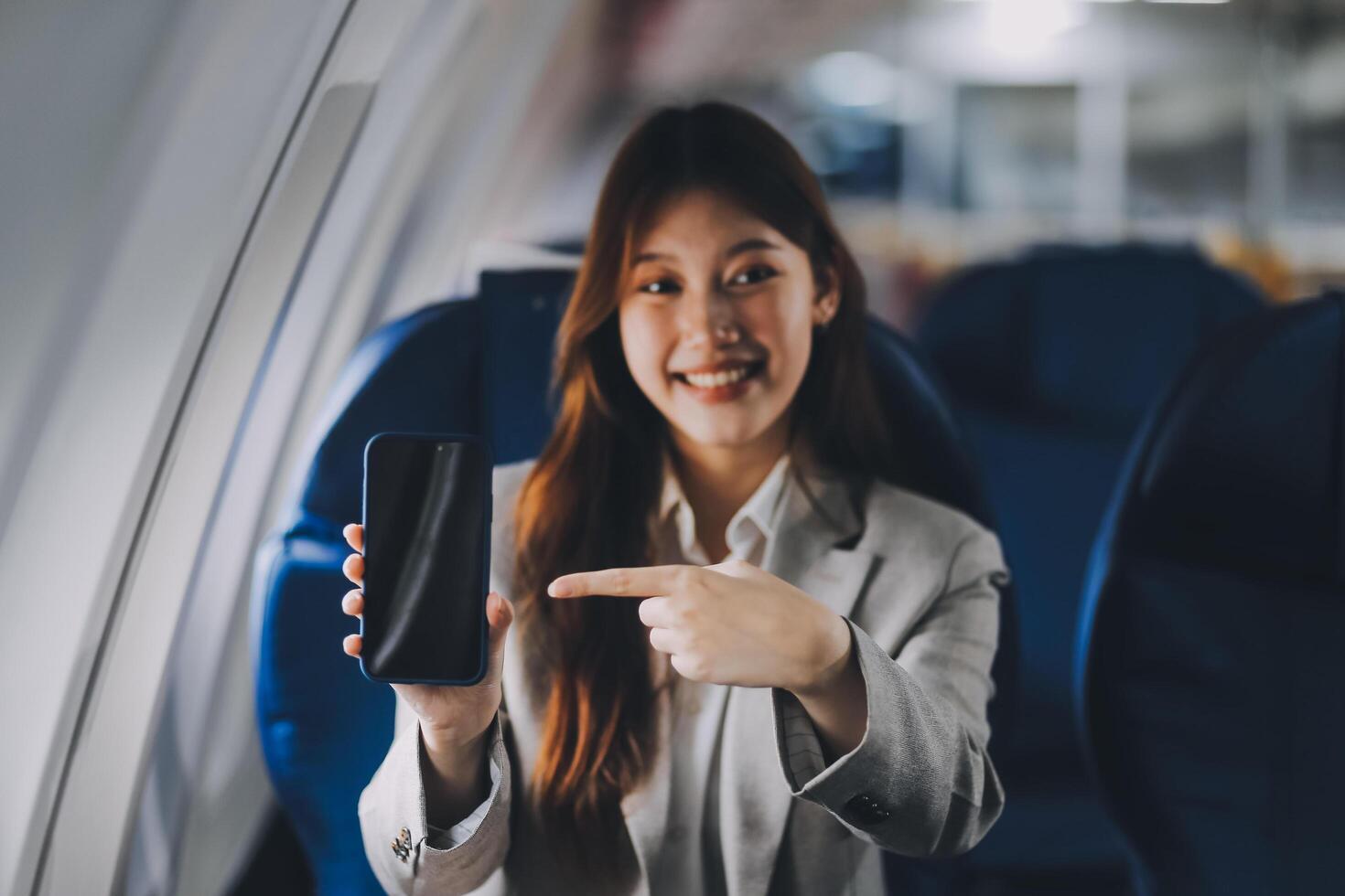 A young Asian woman, seated as an airplane passenger, contemplates dollar bills, reflecting on lucrative opportunities and aspirations towards billionaire status. photo