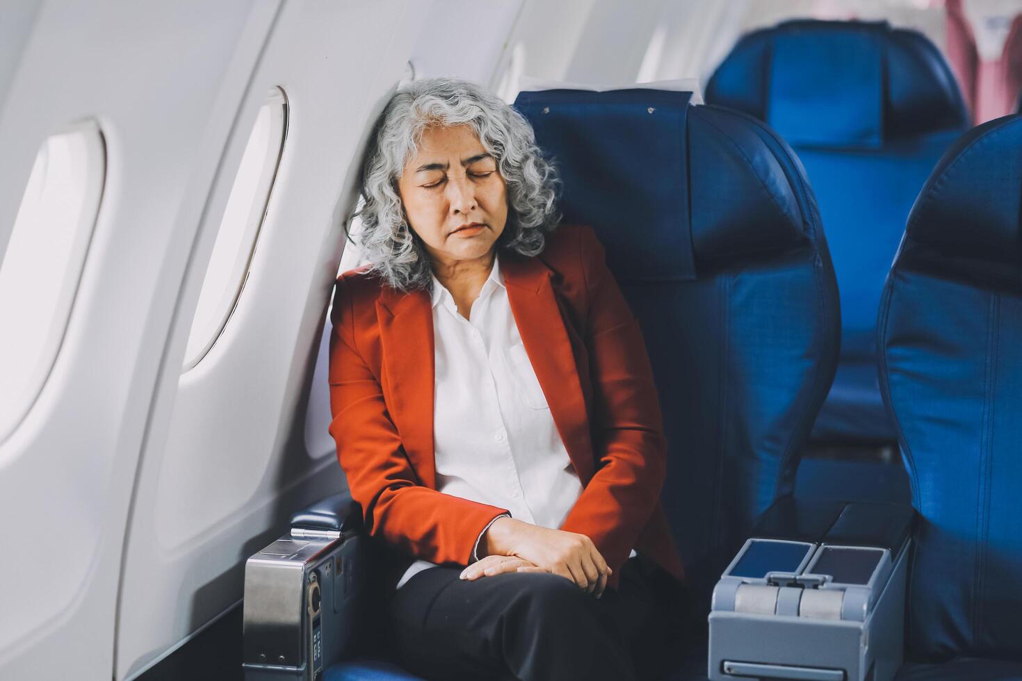 Mature with headache with nausea feeling sick while sitting in the airplane , Passengers near the window. photo