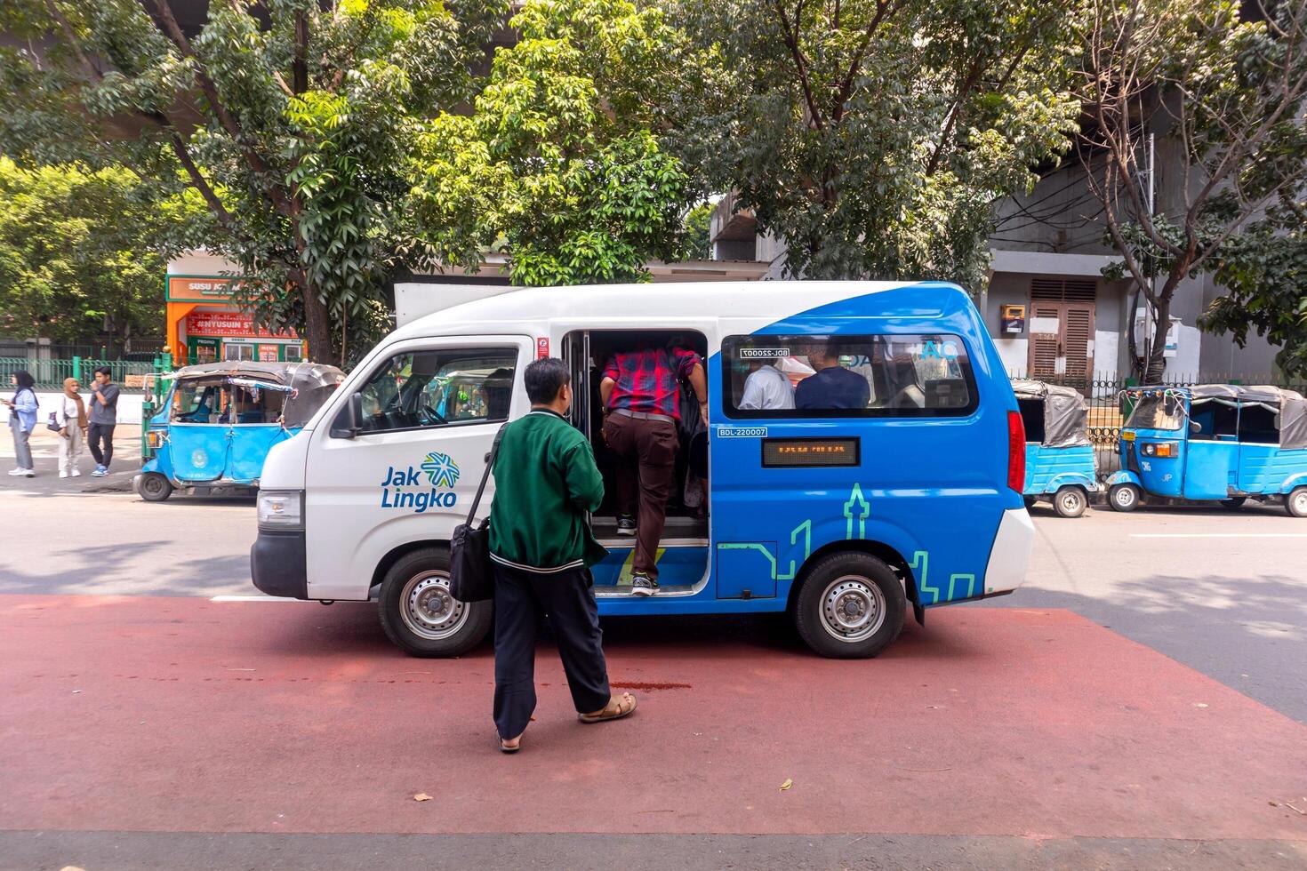Jakarta, Indonesia, 2024 - A public minibus or public transportation car stops to pick up passengers on the street in Jakarta photo