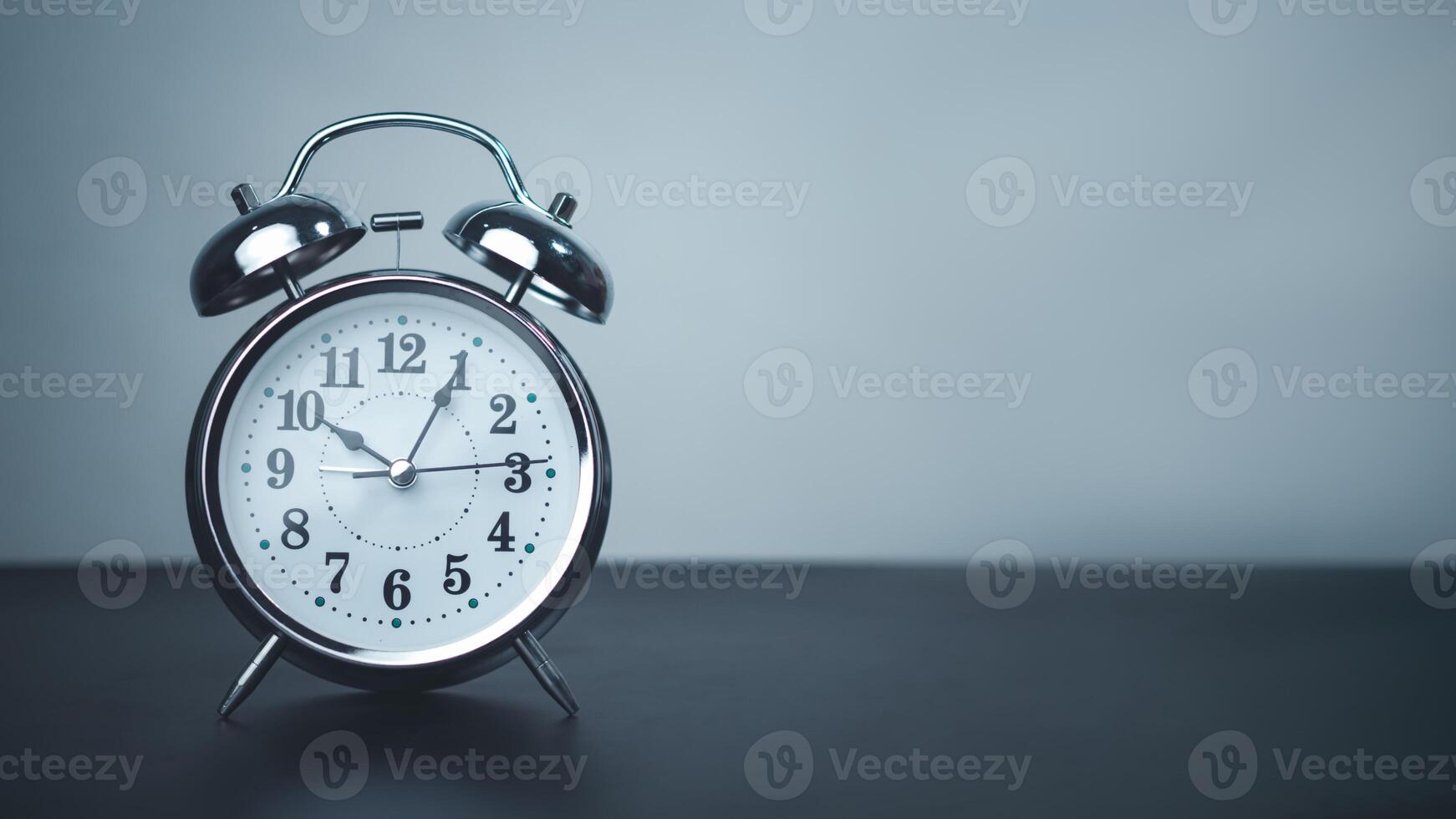 White alarm clock on black table with copy space for preparation of Merry Christmas and Happy new year concept, Start new business, Start up, New trend to next year concept. photo