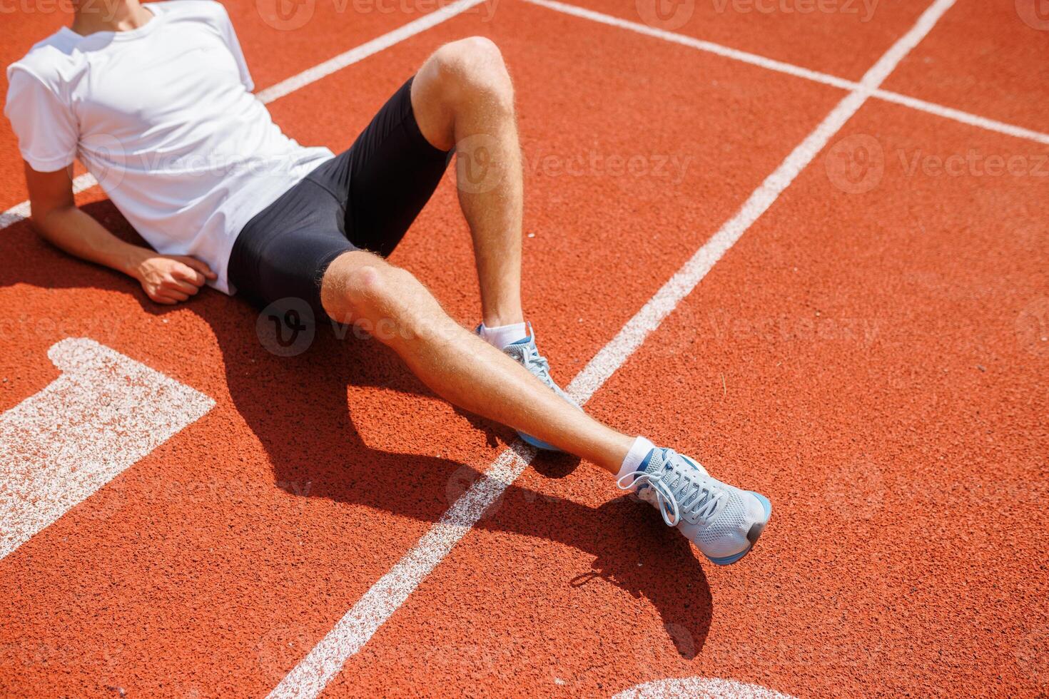 Athlete resting on running track photo
