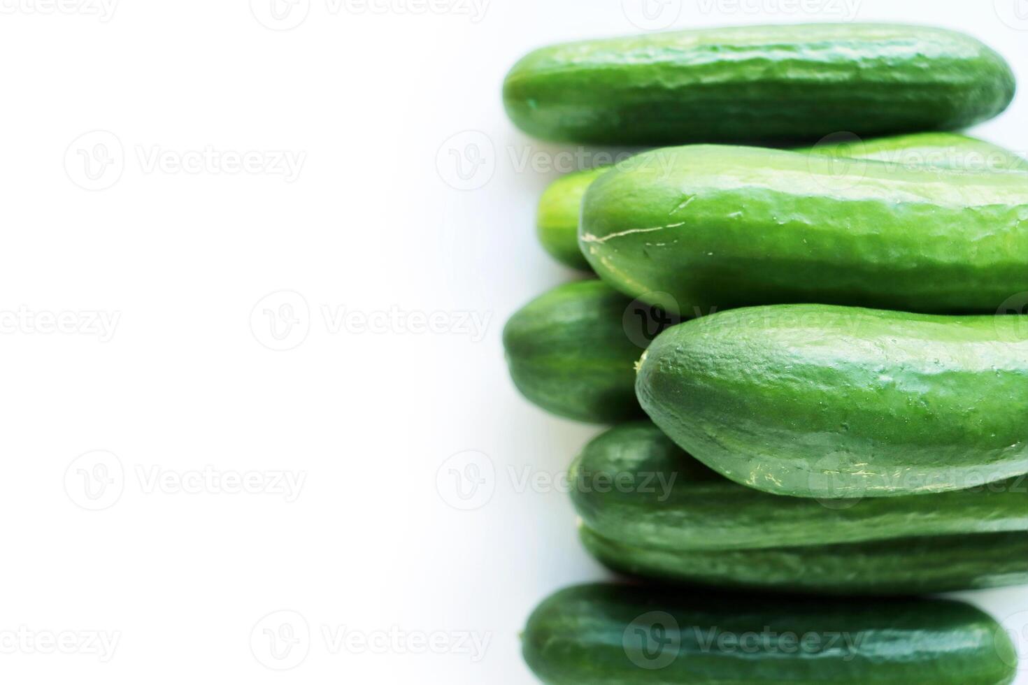 Isolated Heap of green Cucumbers, group of fresh cucumbers on the white background. Close-up, top view, macro, copy space photo