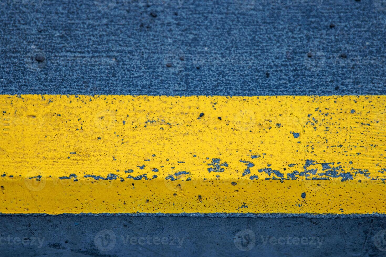 Yellow painted road marking on asphalt background. Detailed closeup of weathered yellow street line. For urban, industrial, and design projects requiring a gritty, realistic touch. Copy Space photo