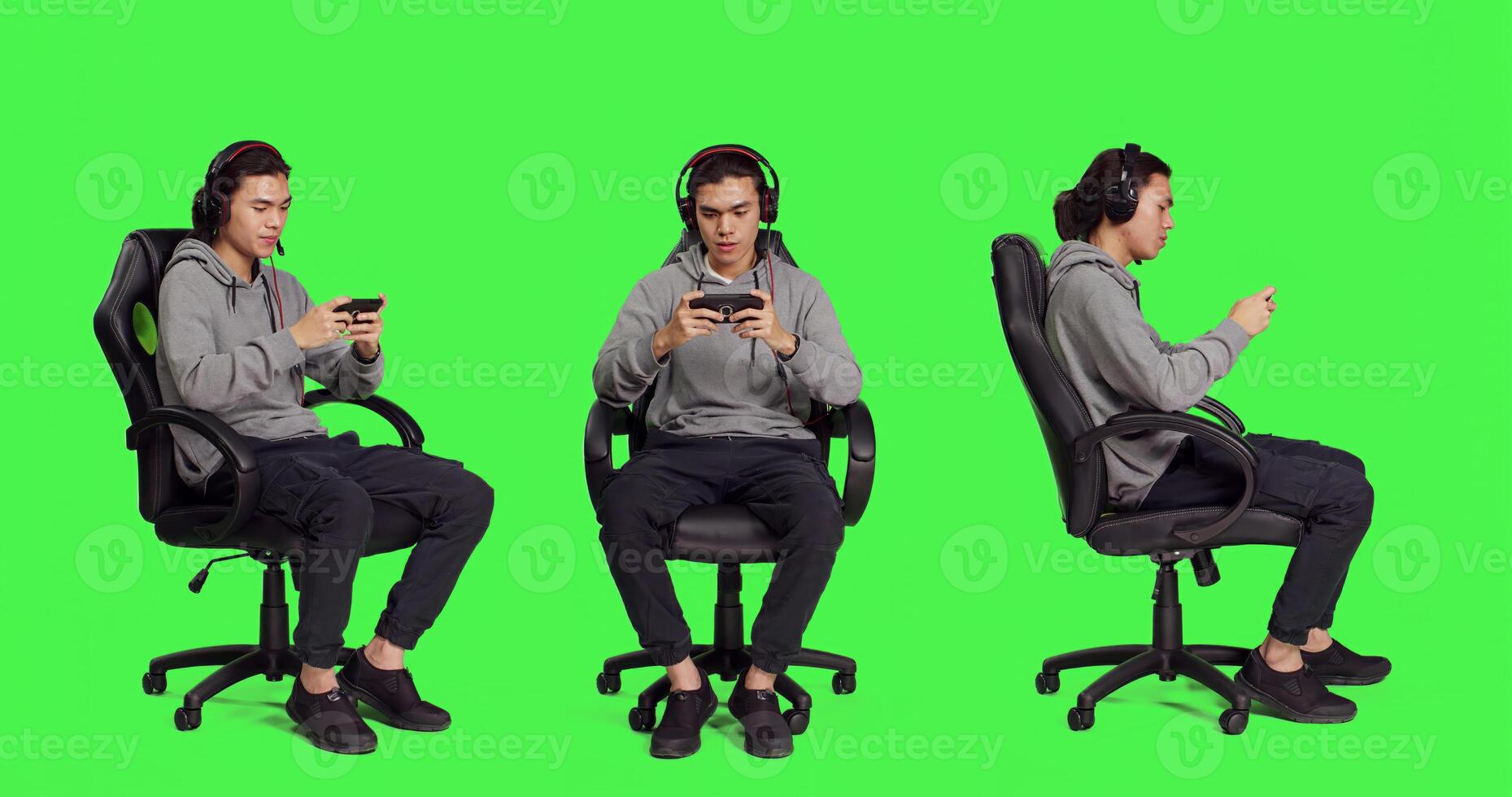 Over full body greenscreen, asian adult enjoys mobile videogames holding smartphone and participating in online action contest. Gamer uses phone to participate in new roleplaying battle. photo