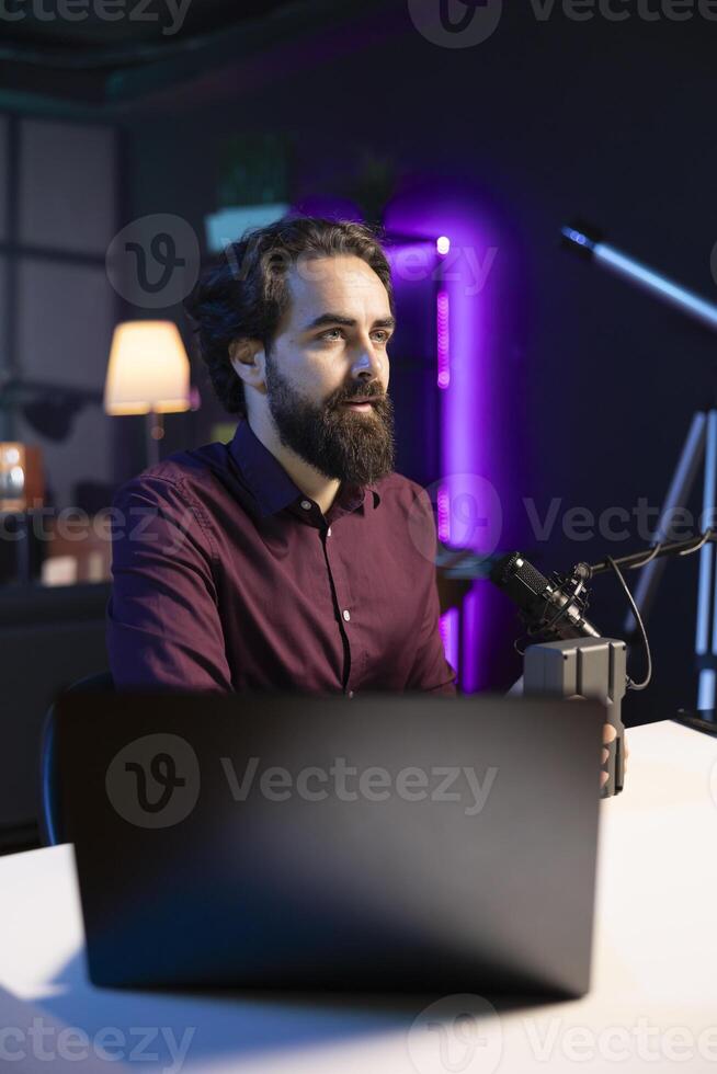 Tech expert filming technology review of newly released V mount battery, analyzing it before endorsing it to audience. Media star showing charging device to his subscribers photo