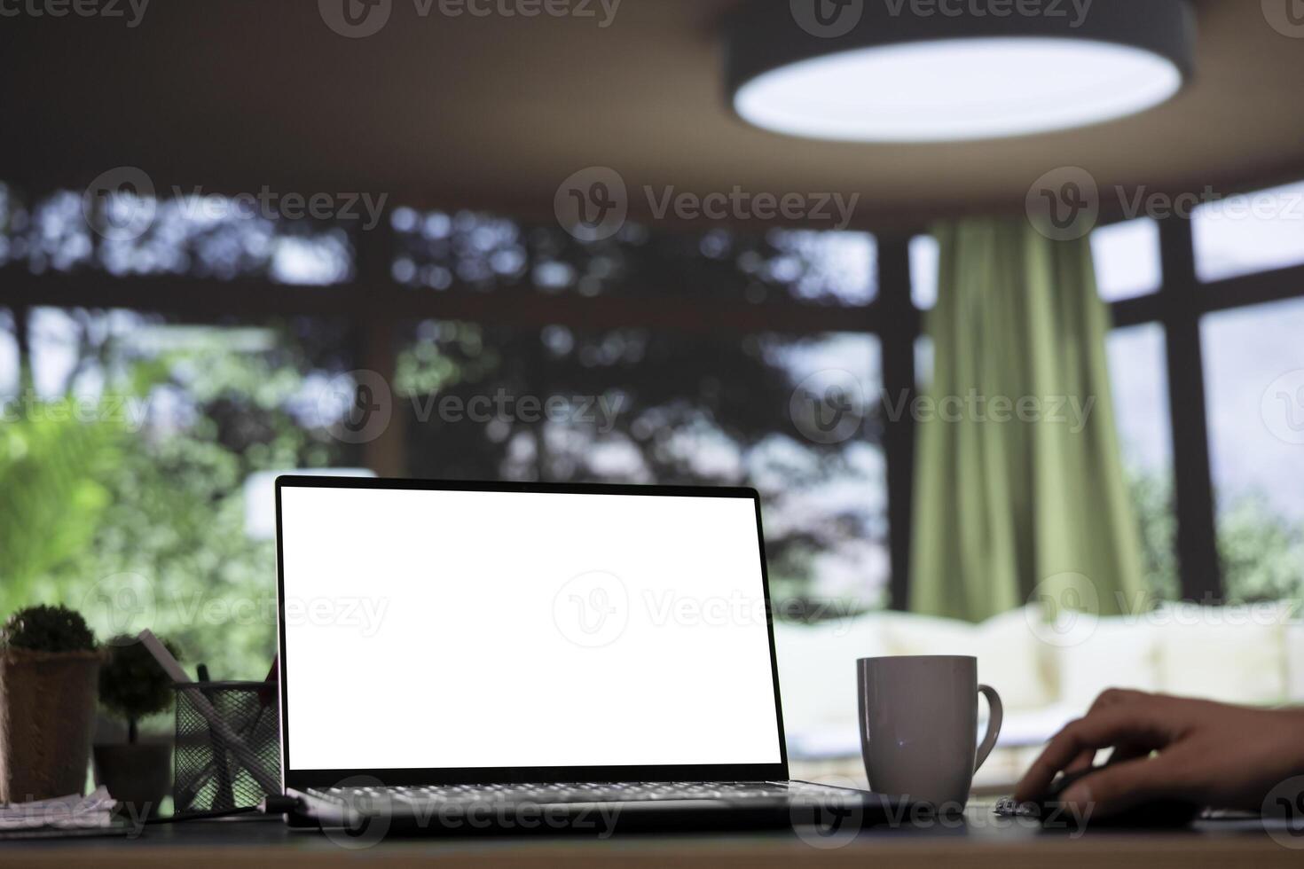 Billionaire business leader uses white screen on laptop at his impressive mountain cabin, viewing pc projection of blank copyspace display. Company CEO interacts with isolated mockup layout. photo
