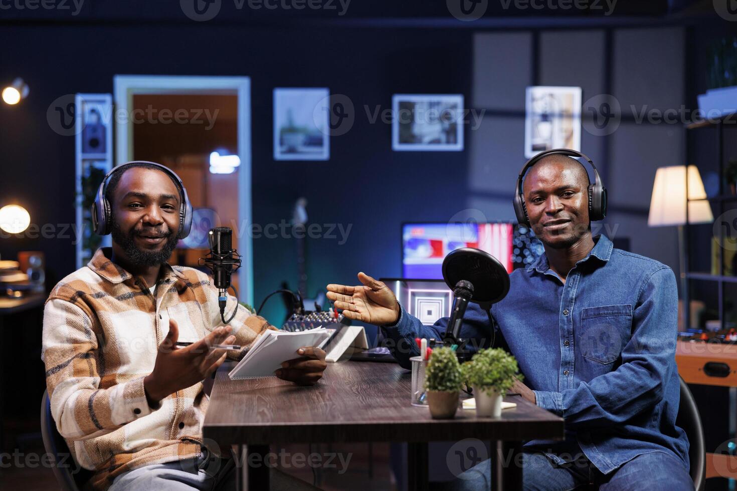 African american male vloggers, discussing various topics and interacting with fans, using professional recording equipment to produce high quality content for online streaming services. photo