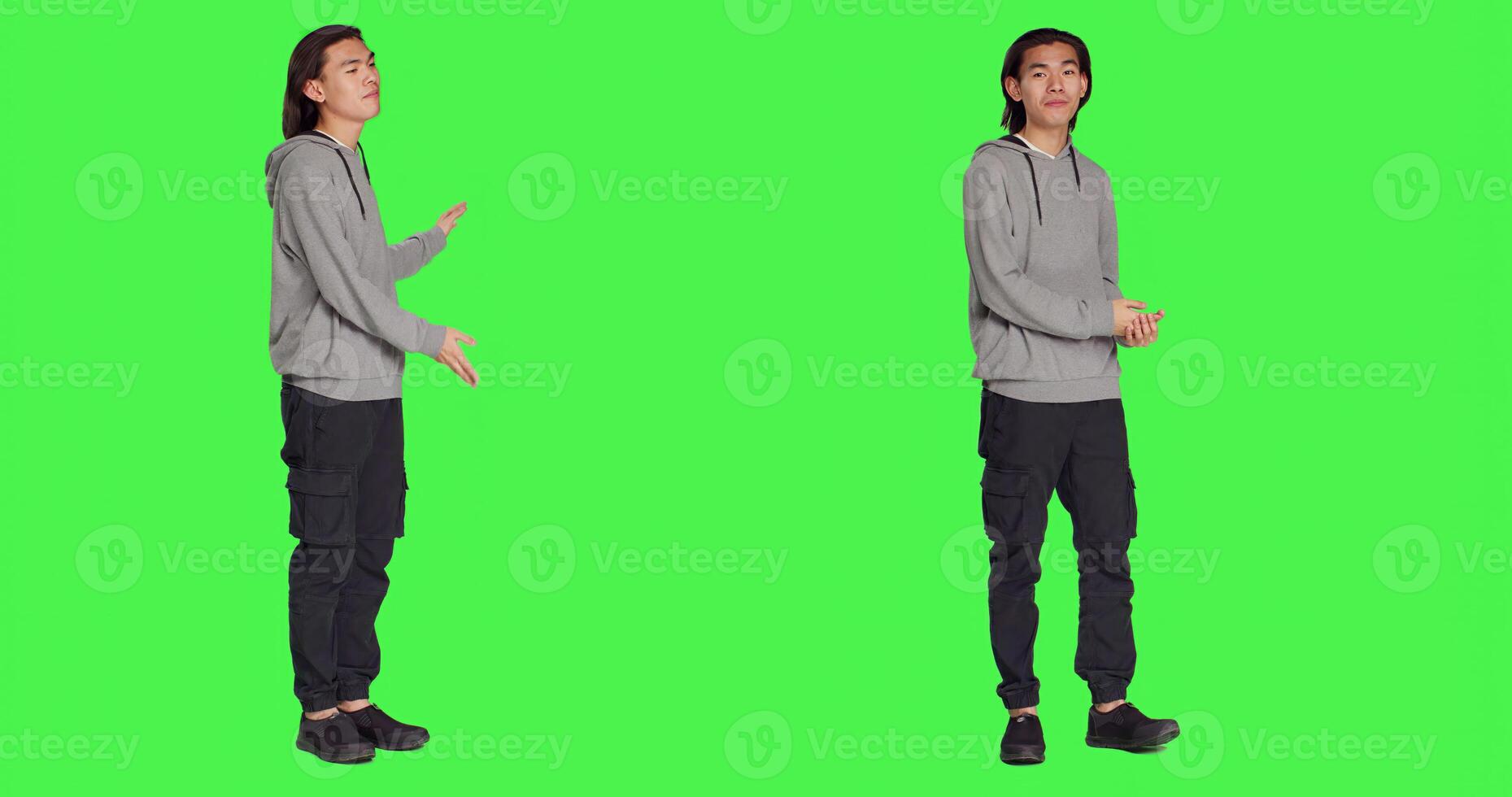 Male person creating advertisement and showing something to left or right sides on camera, pointing at thing over full body greenscreen. Young adult advertising slogan for marketing commercial. photo