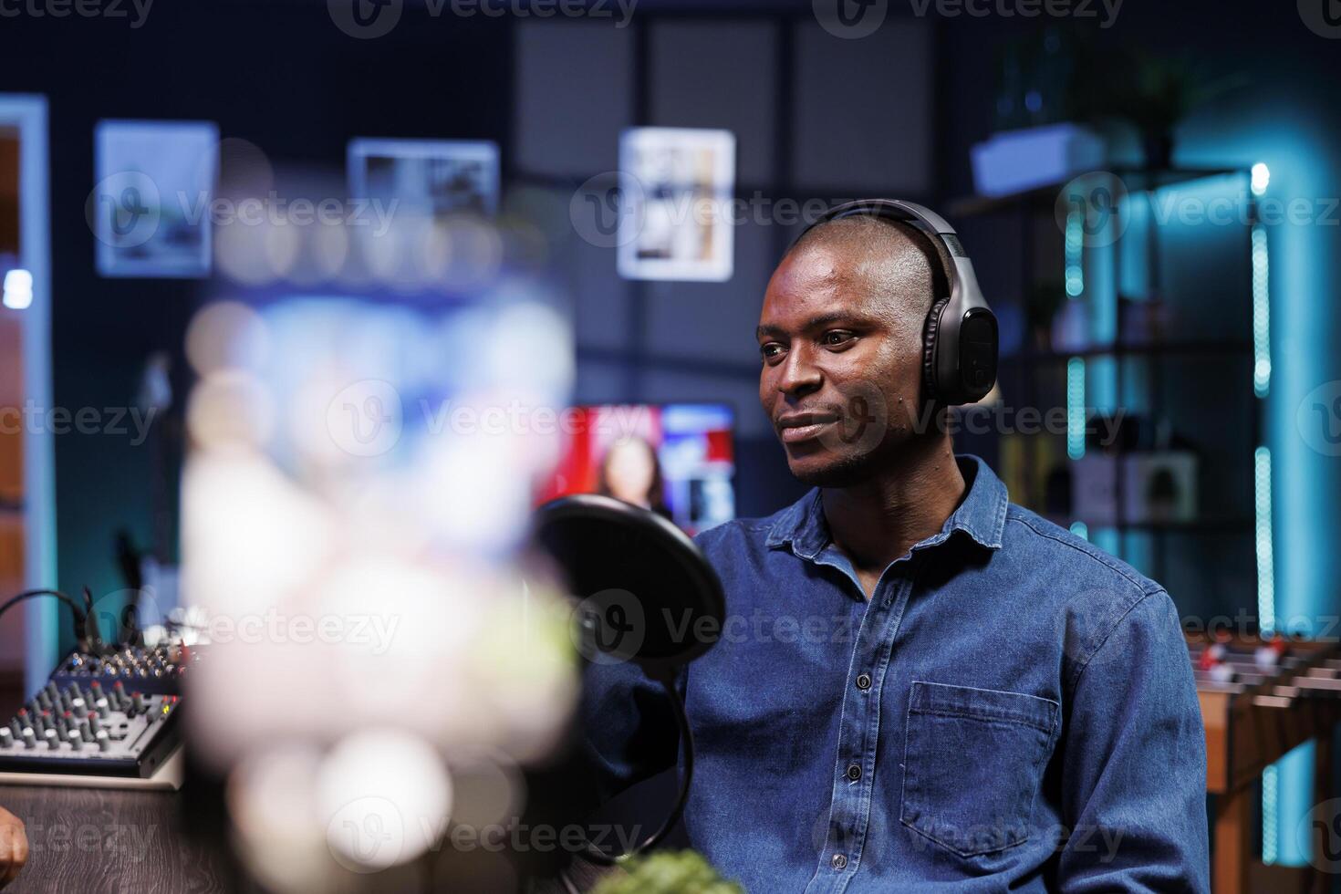 Close up shot of a blogger recording a vlog using a smartphone on a tripod. The content creator is using videography equipment to record for a podcast channel on social media. photo