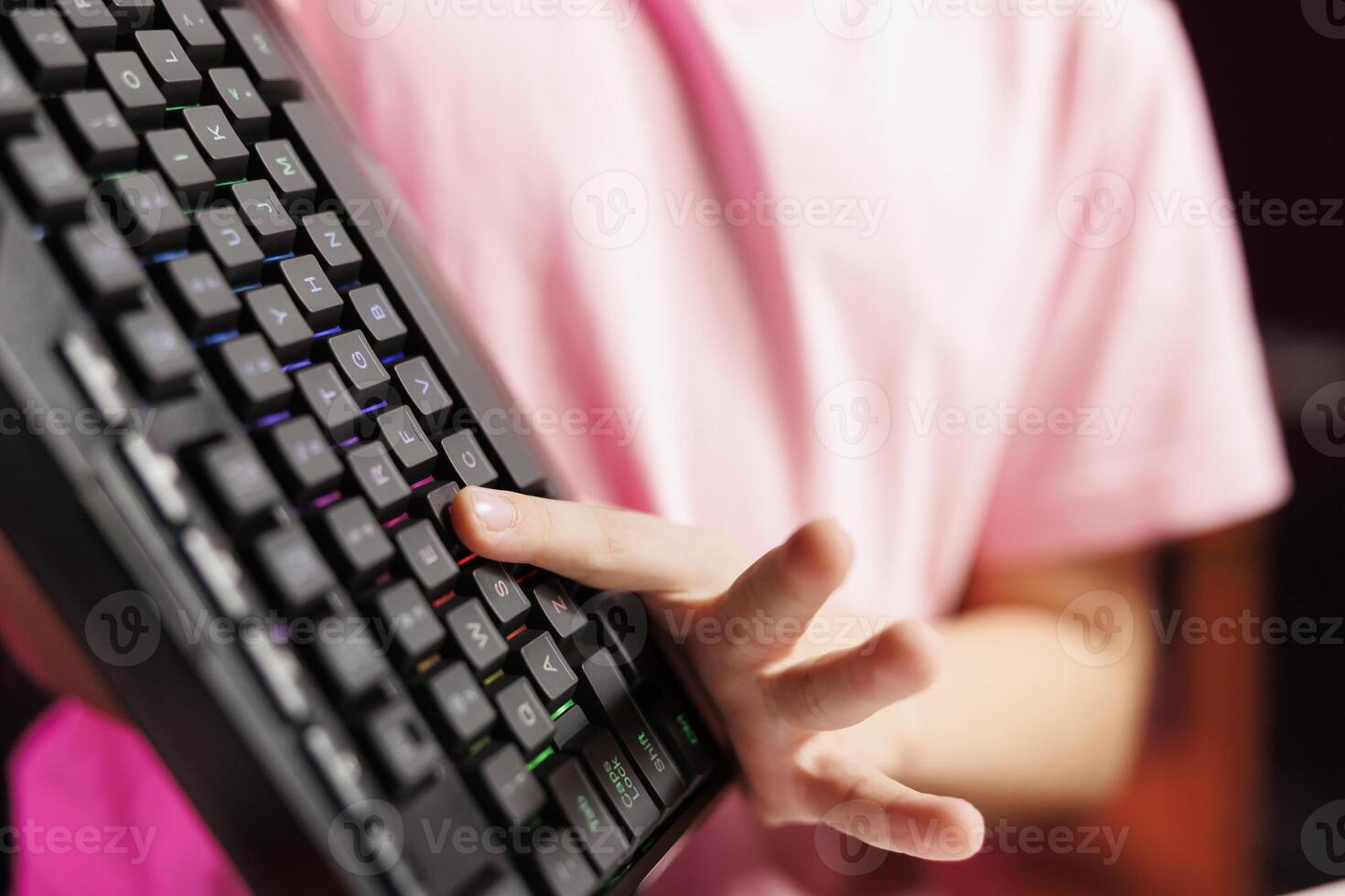 Close up on mechanical keyboard received by cute girl from sponsoring brand to promote it. Focus on wireless Bluetooth computer peripheral advertised by young child, testing keys photo