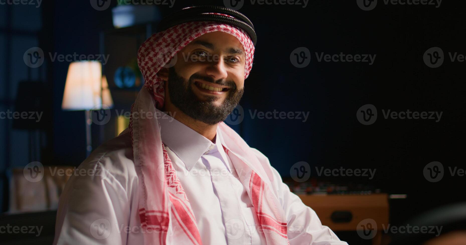 Portrait of smiling teleworker remotely working in cozy stylish apartment writing on paper. Employee at home cross referencing information, transcribing data from laptop to notepad photo