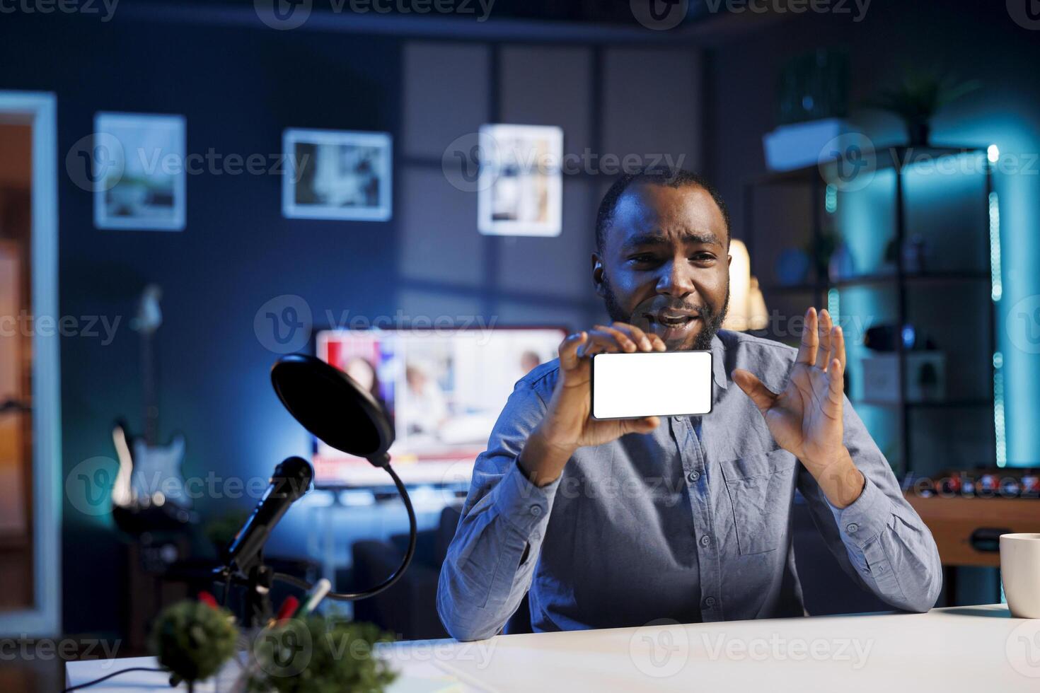 African american man filming himself watching internet videos on mockup smartphone requested by followers. Media star reacting to online clips sent by subscribers using isolated screen mobile phone photo