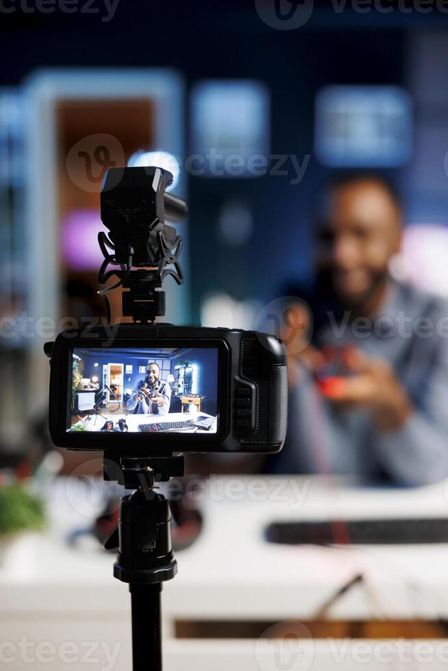 Focus on professional production gear used for capturing footage of media star in blurry background filming tech reviews for his online channel, showcasing computer peripherals photo