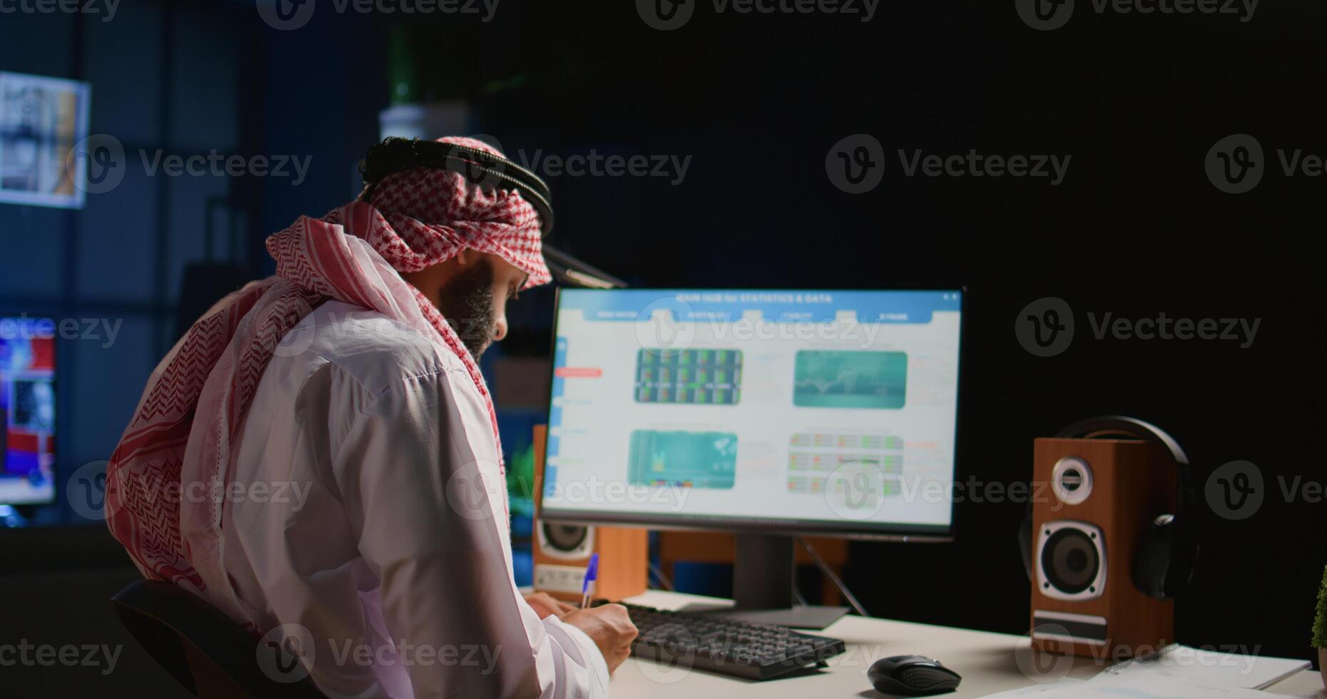 Muslim broker investor employee typing on keyboard in office, checking stock exchange valuation financial profit numbers. Arabic stockholder looking at market shares growth charts, handheld camera shot photo