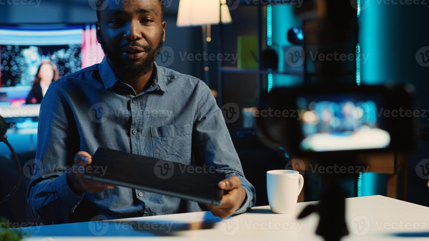Technology content creator filming review of newly released gaming laptop, unboxing it and giving feedback to his fanbase. Online star endorsing sponsor branded device to subscribers photo