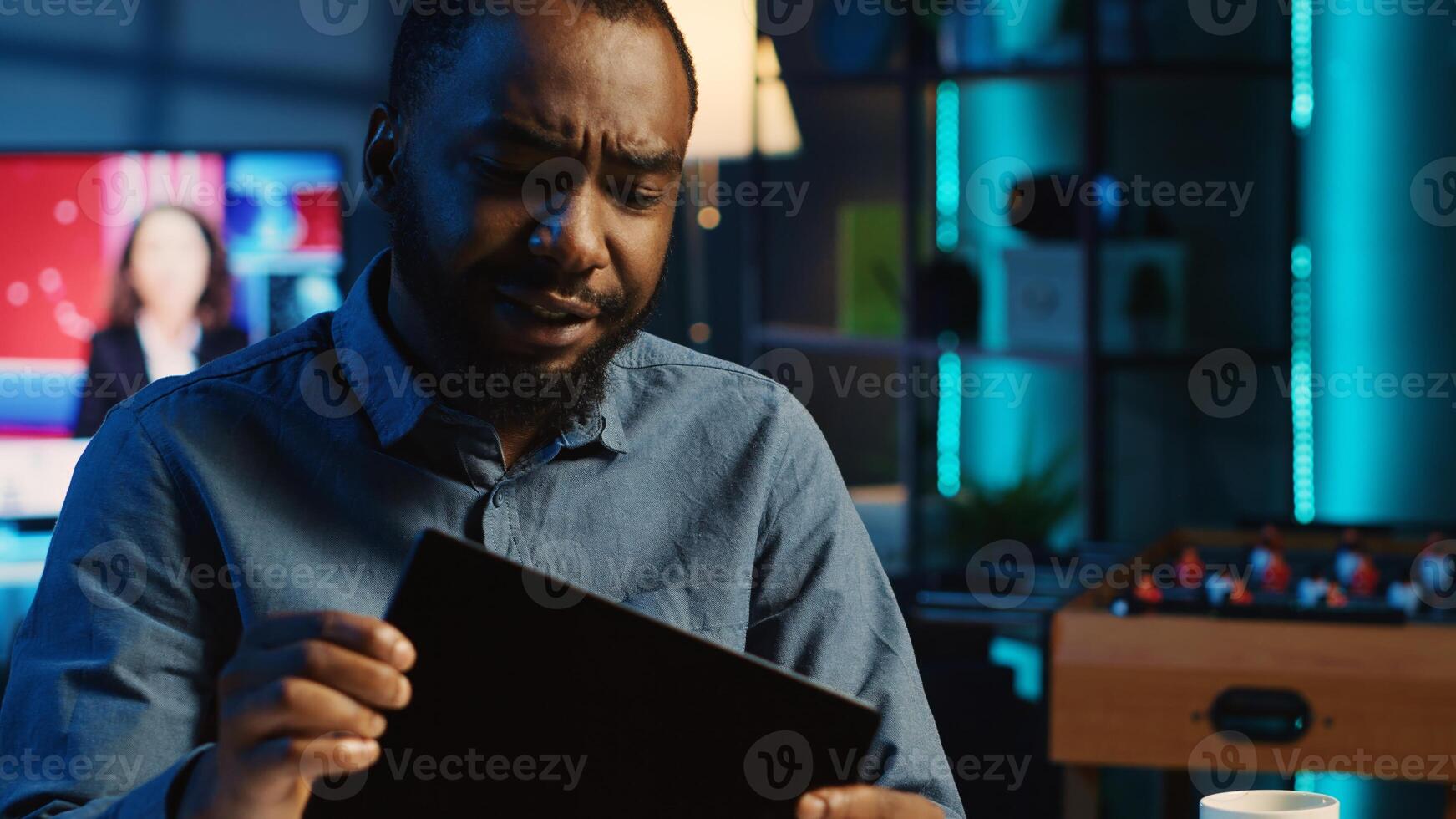 African american content creator filming technology review of newly launched tablet, unpacking it and presenting specifications to audience. Media star showing device to viewers photo