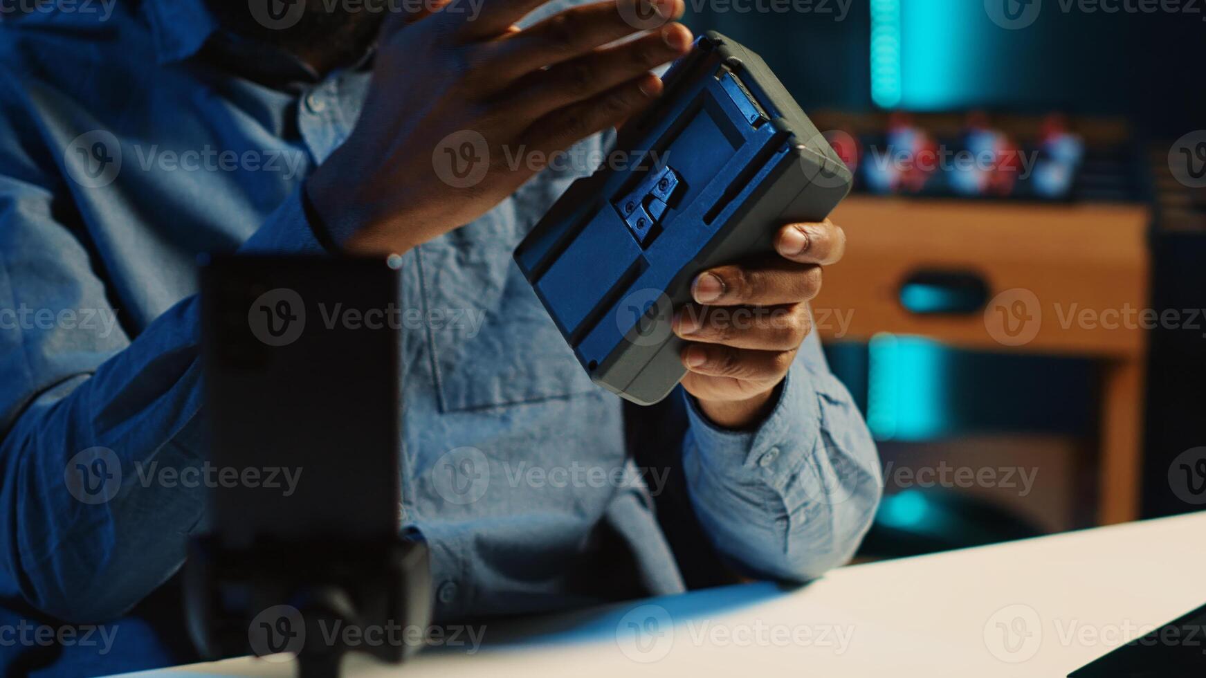 Content creator filming sponsored review of lithium V mount battery, unboxing it and presenting to audience. Media star presenting charging accumulator for viewers, close up photo