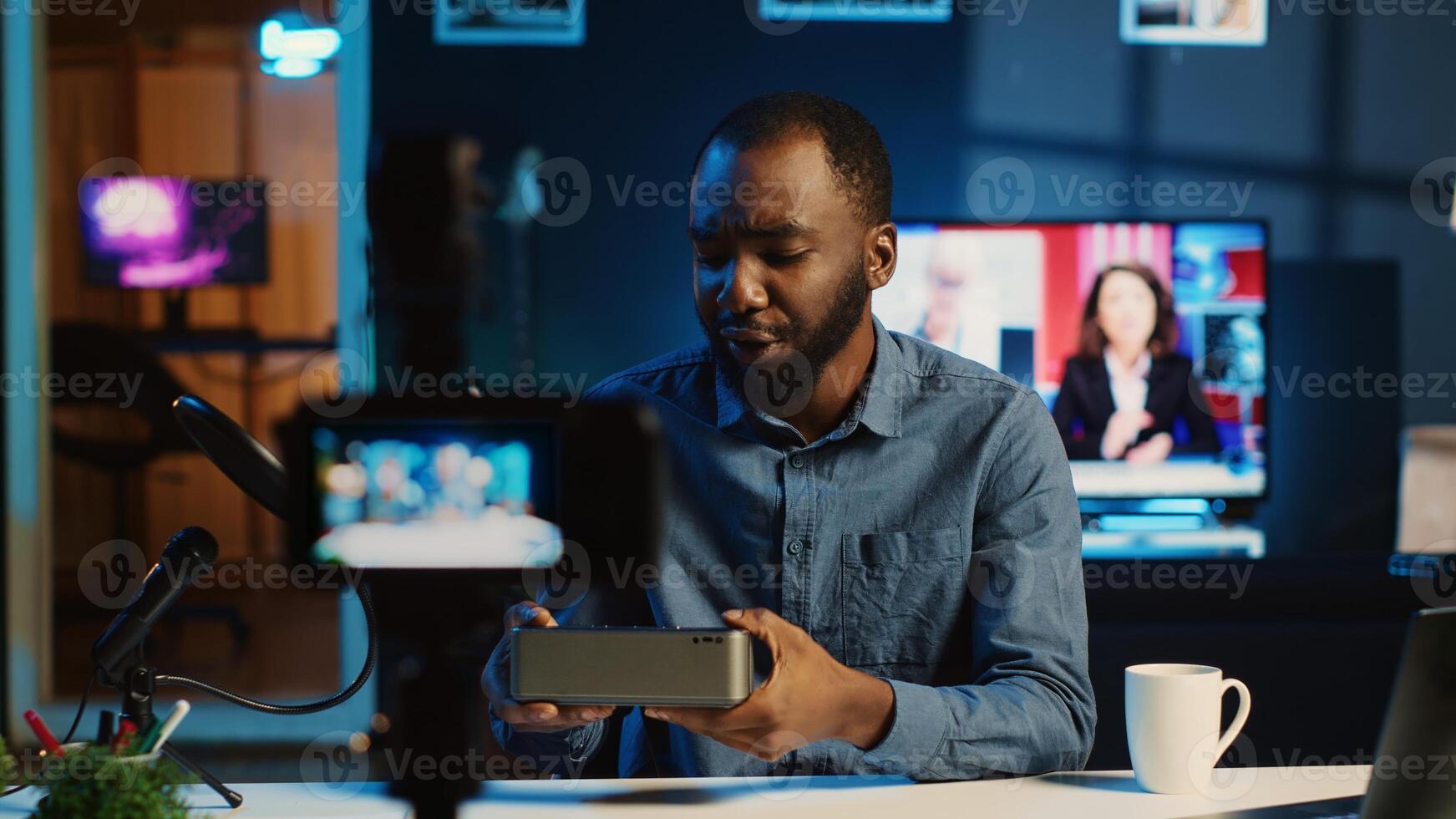 Content creator doing technology review of wireless portable speaker for online platforms channel. African american influencer presenting music playing device to his audience photo
