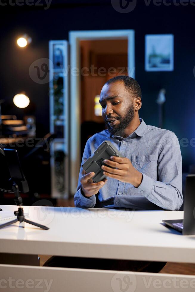 Influencer reviewing V mount battery, expressing dissatisfaction with subpar quality. Content creator shooting for online channel, displeased with professional lithium accumulator performance photo