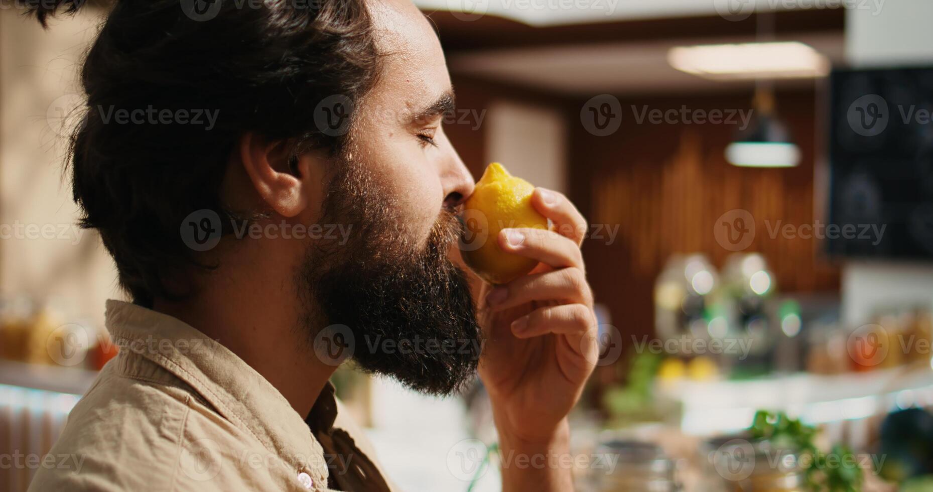 Man in bio supermarket shops for farm grown fruits, getting dopamine rush while smelling them. Customer experiences bliss while feeling nice lemons aroma in eco friendly food shop, zoom in shot photo