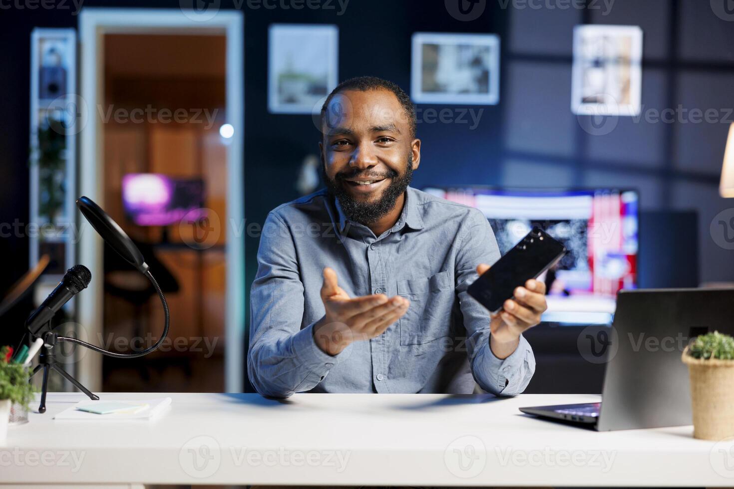 Internet show host promoting smartphone received from sponsoring brand to fans. BIPOC media star does influencer marketing on online channel, urging followers to purchase mobile phone photo