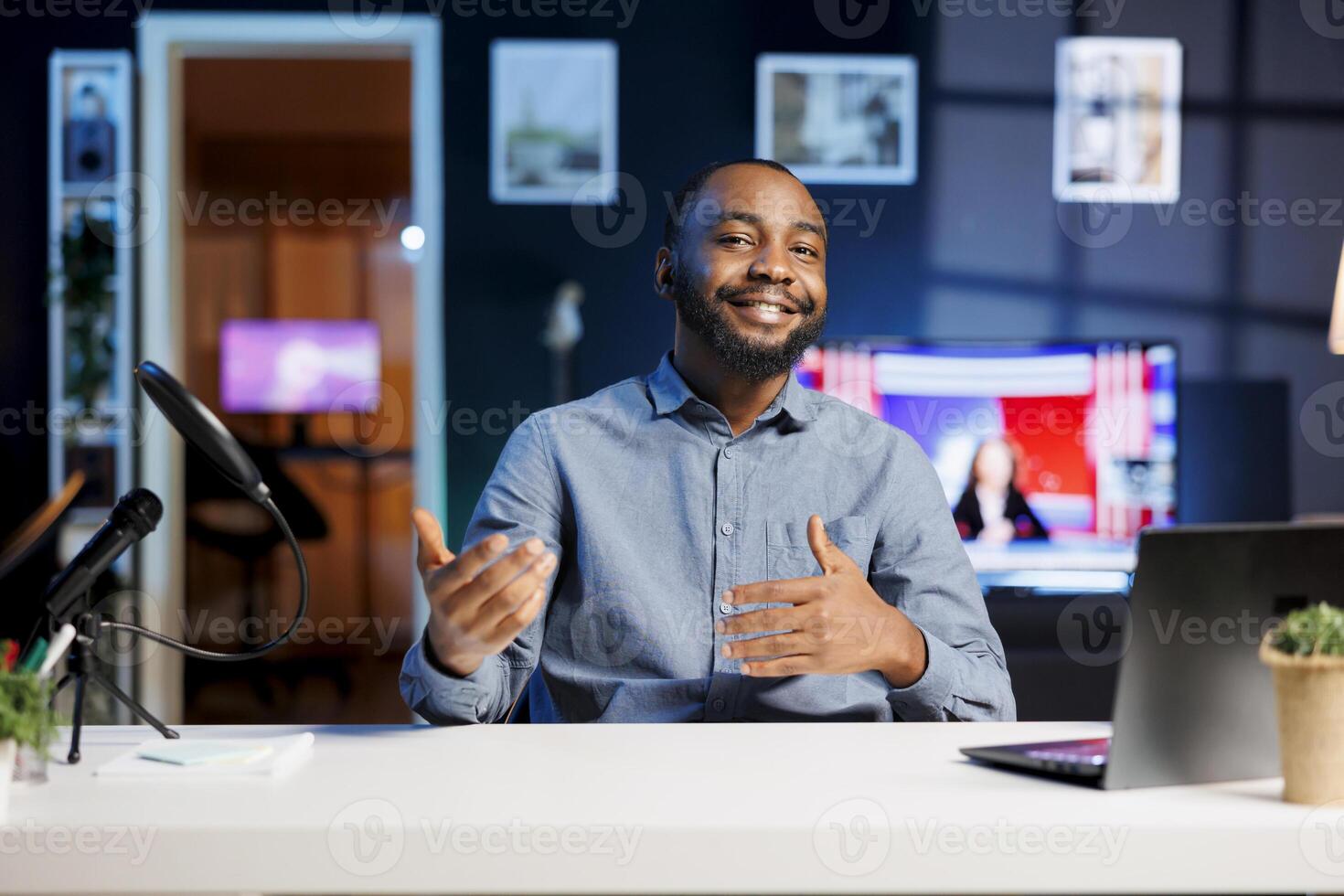 Cheerful BIPOC content creator doing travelling recommendations type of for fans, giving tips, filming in his apartment. Online show host sharing with viewers his favorite locations in the world photo