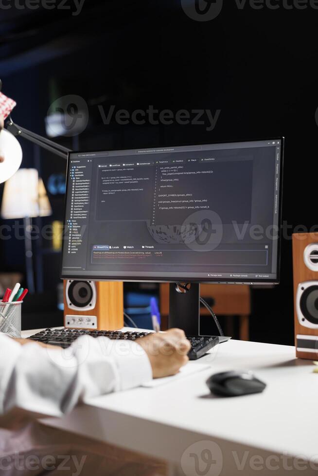 Detailed shot of computer screen displaying sleek software app interface, highlighting app development and user interface design. Image shows man engrossed in writing and examining code. photo