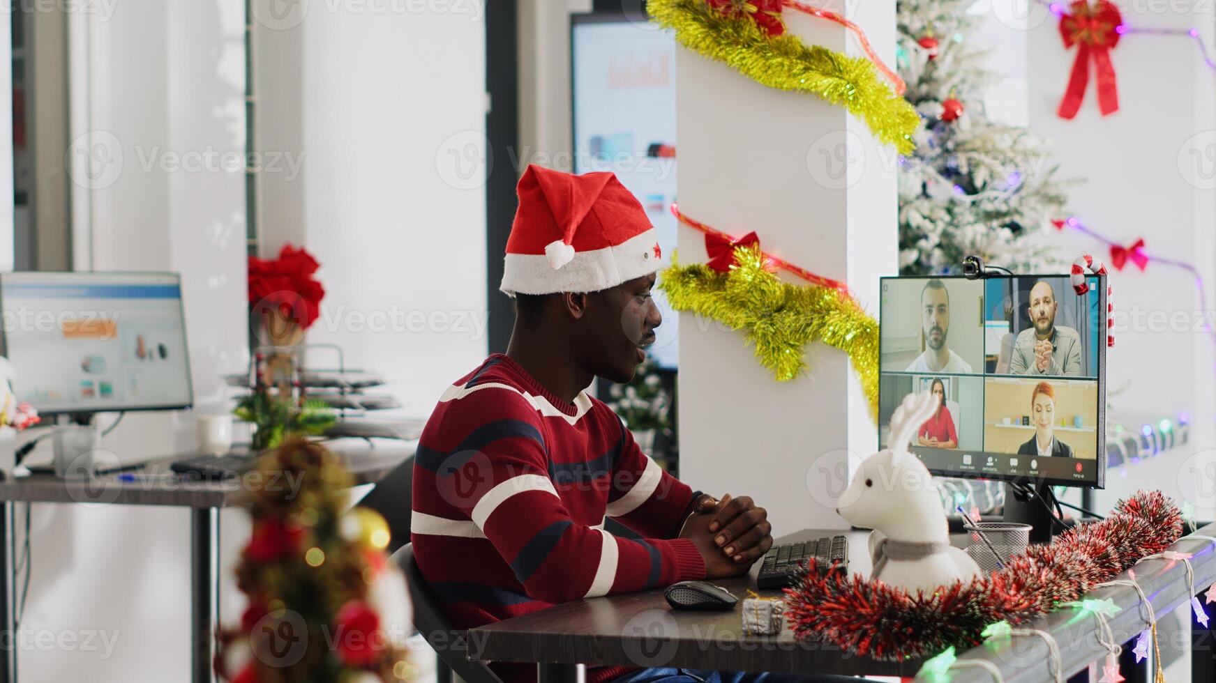 Worker in online videocall listening to managers evaluation in Christmas decorated office. Staff member in remote teleconference receiving feedback from management executives during xmas season photo