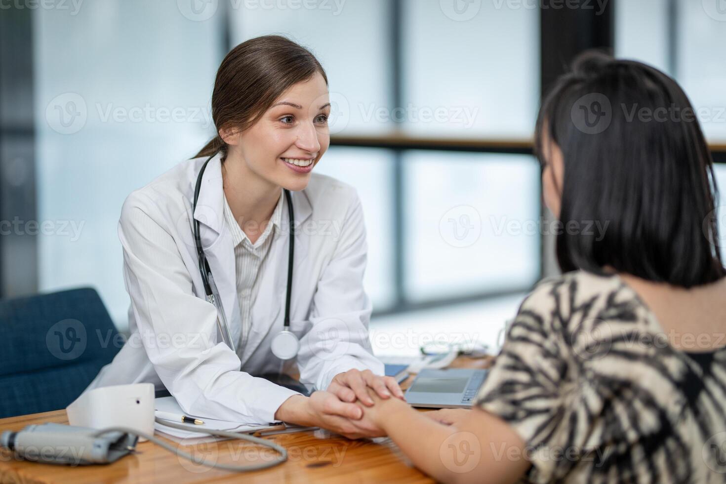 A female doctor showing empathy and comfort to her patient during a consultation in a medical office setting. photo