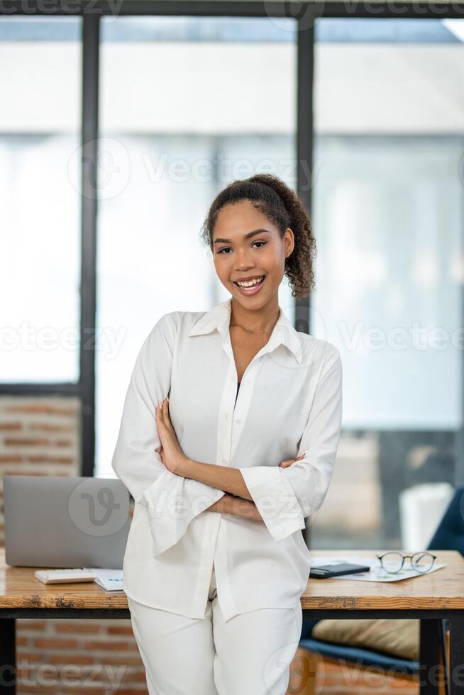 Professional young female entrepreneur standing confidently in a bright, contemporary office environment. photo