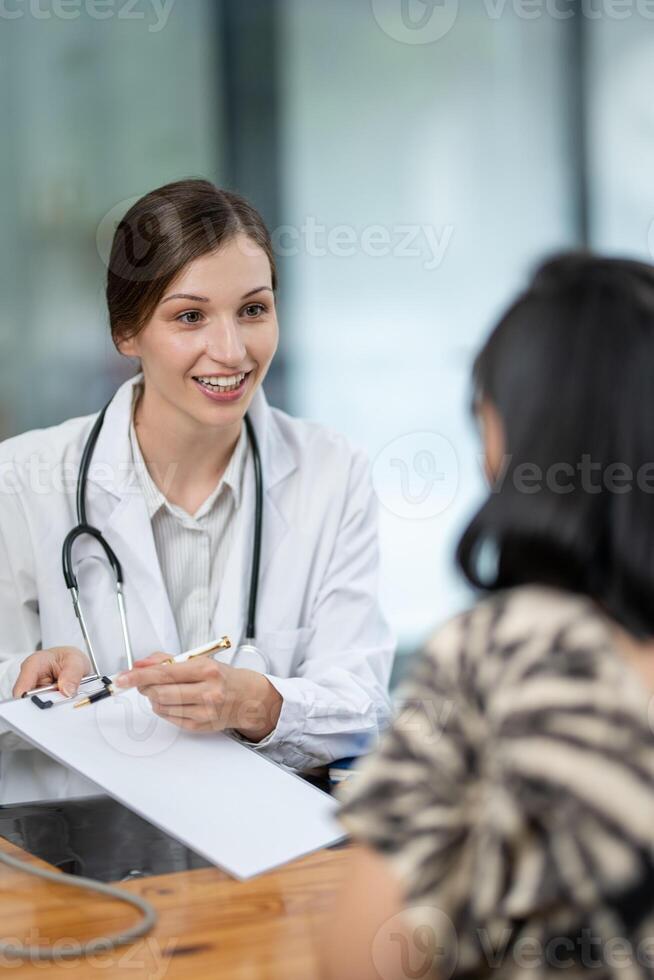 doctor notes while listening to her patient's medical history during a thorough and attentive check-up. photo