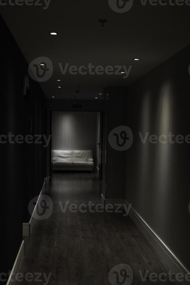 Dark narrow hotel corridor leading to waiting area photo