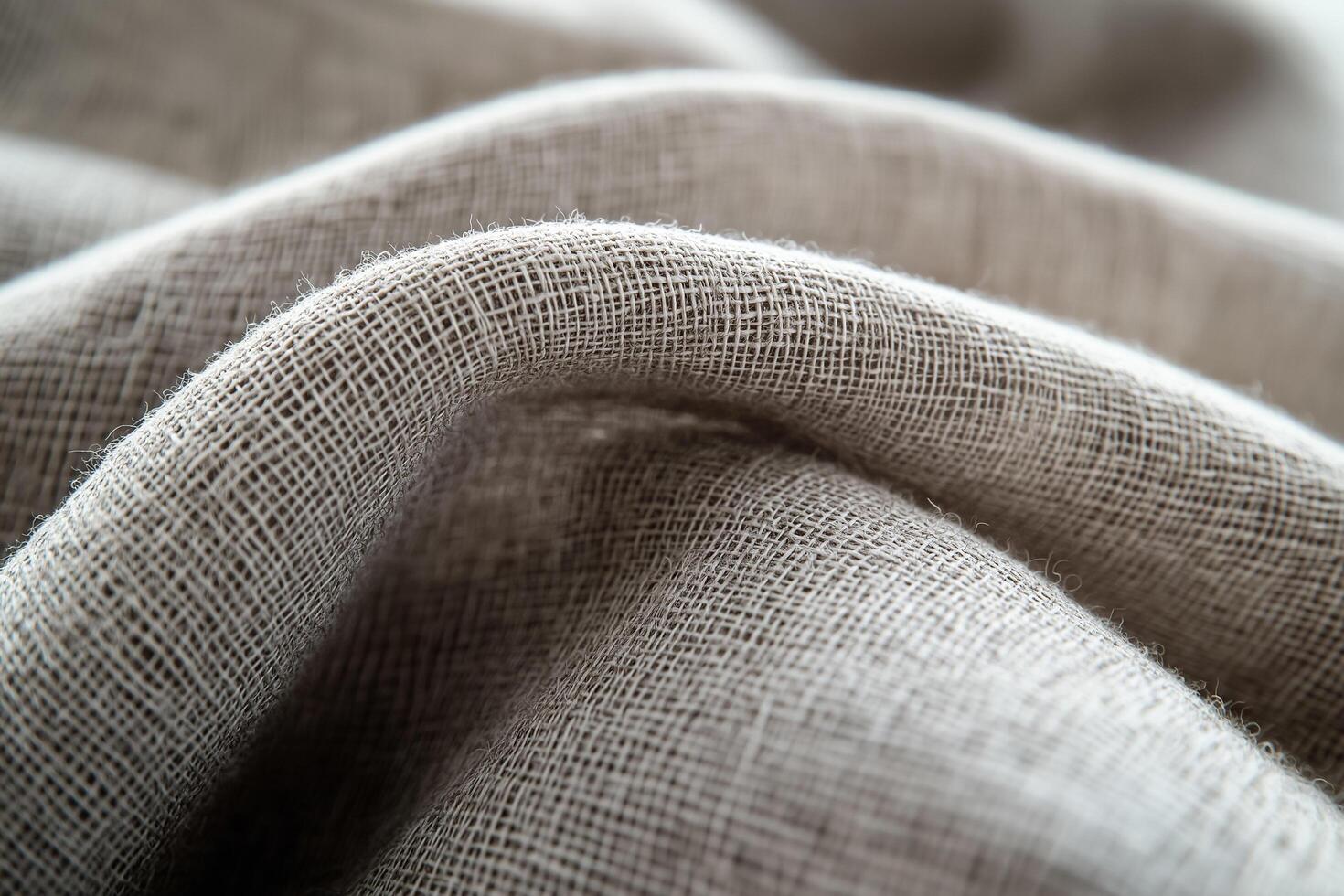 Close-up of textured beige fabric with a natural weave, softly draped in flowing curves, showcasing its organic beauty photo