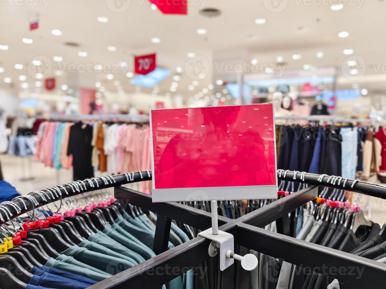 A red sign is on a rack in a clothing store photo