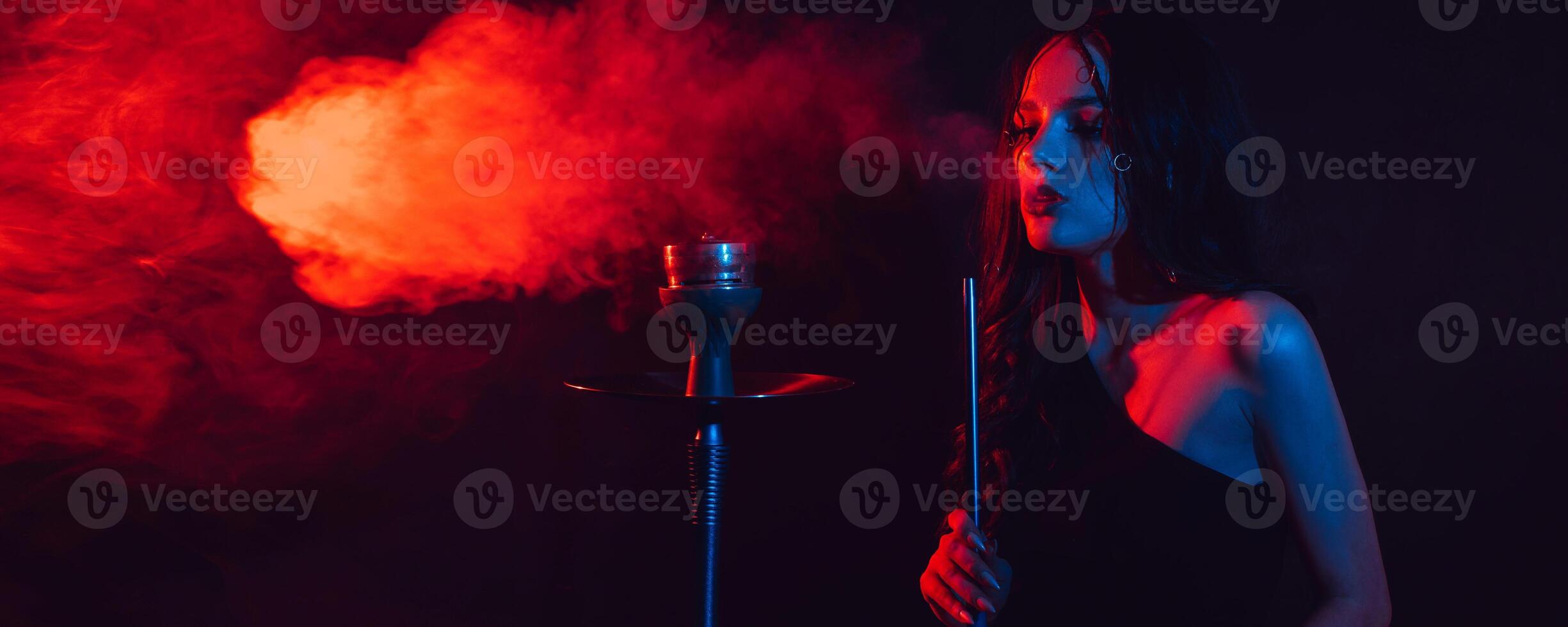 A young girl enjoys smoking a hookah, sheesha. Photo with space for text