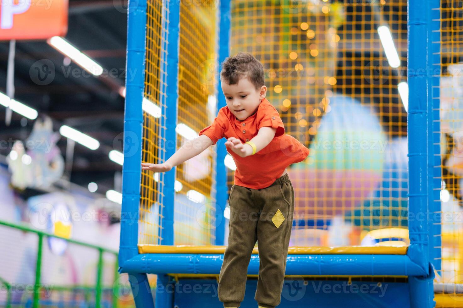 A happy boy jumps on a trampoline in an entertainment center. photo