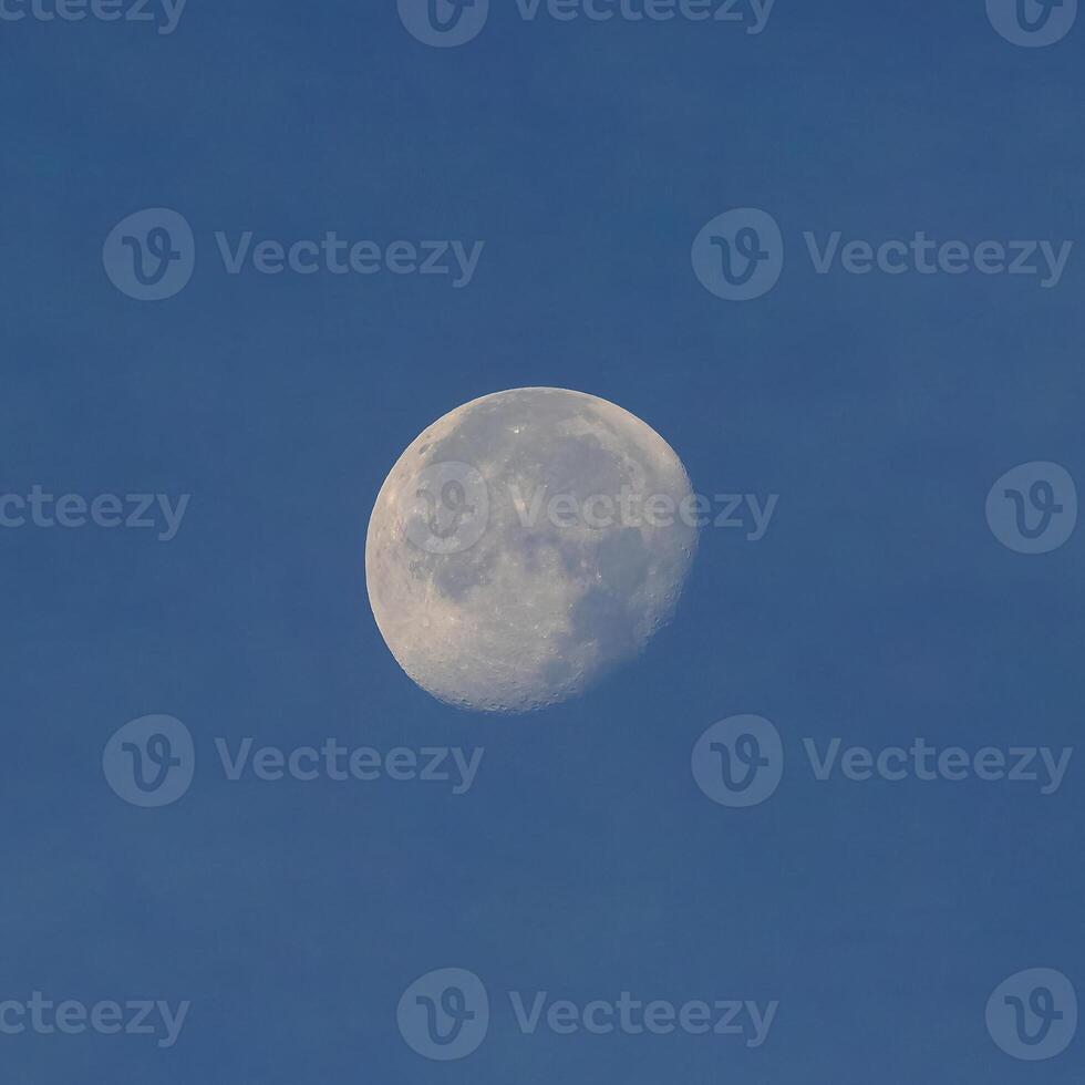 Full moon over blue sky photo