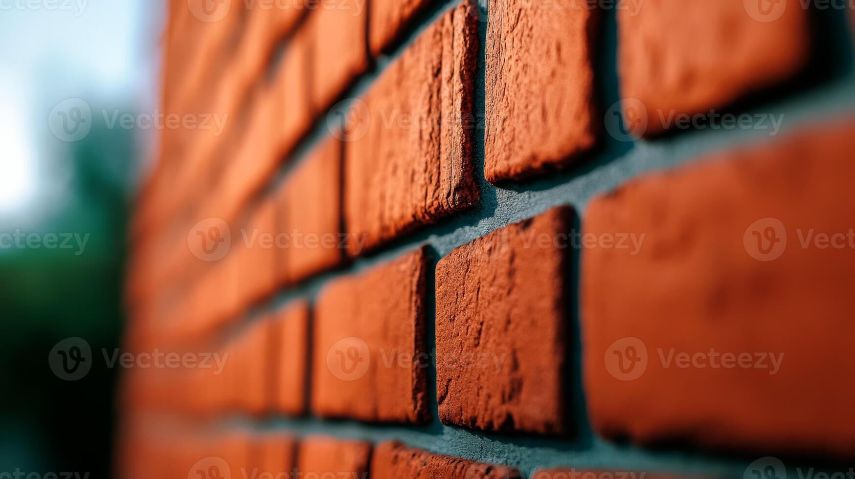 Angled closeup of a rough brick wall painted in burnt orange texture highlighting brick seams and minor surface flaws giving a warm and rustic appeal photo