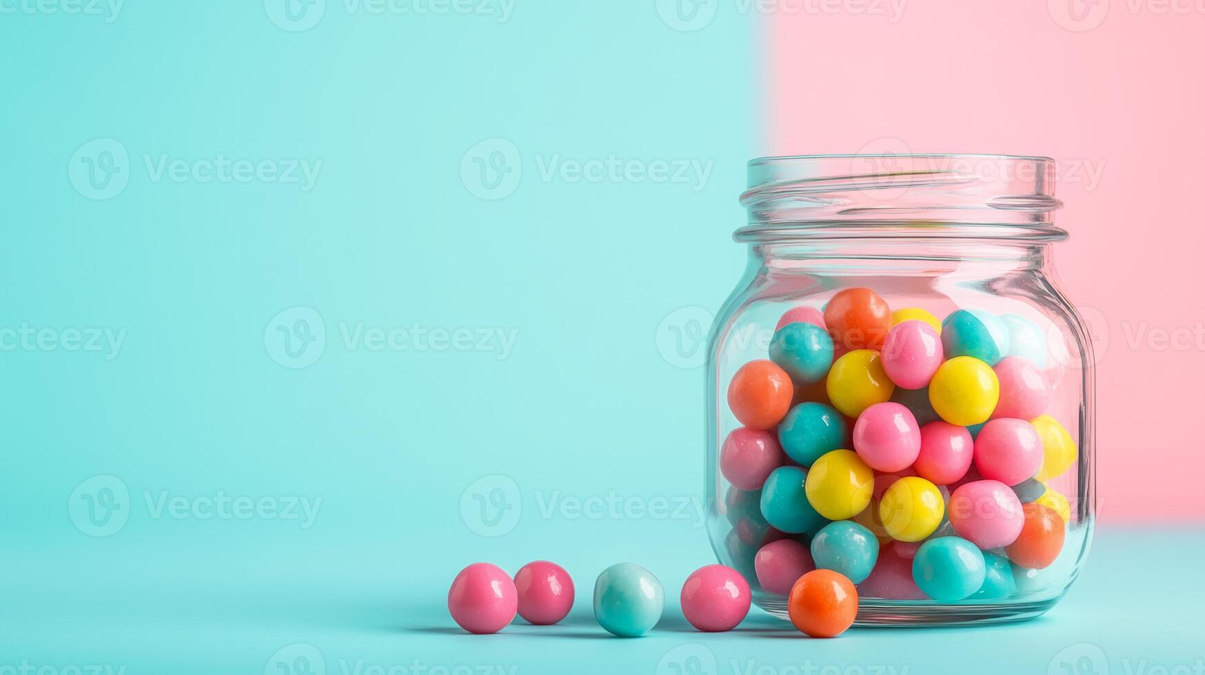 Wide angle shot of colorful bubble gum balls spilling out of a vintage glass jar with a pastel background gradient of blue and pink photo