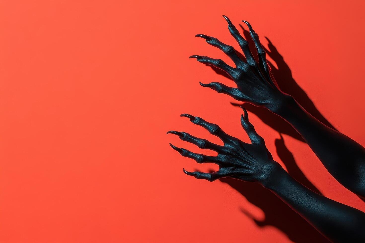 Black Clawed Hands Reaching Out on Bright Red Background with Dramatic Shadows photo