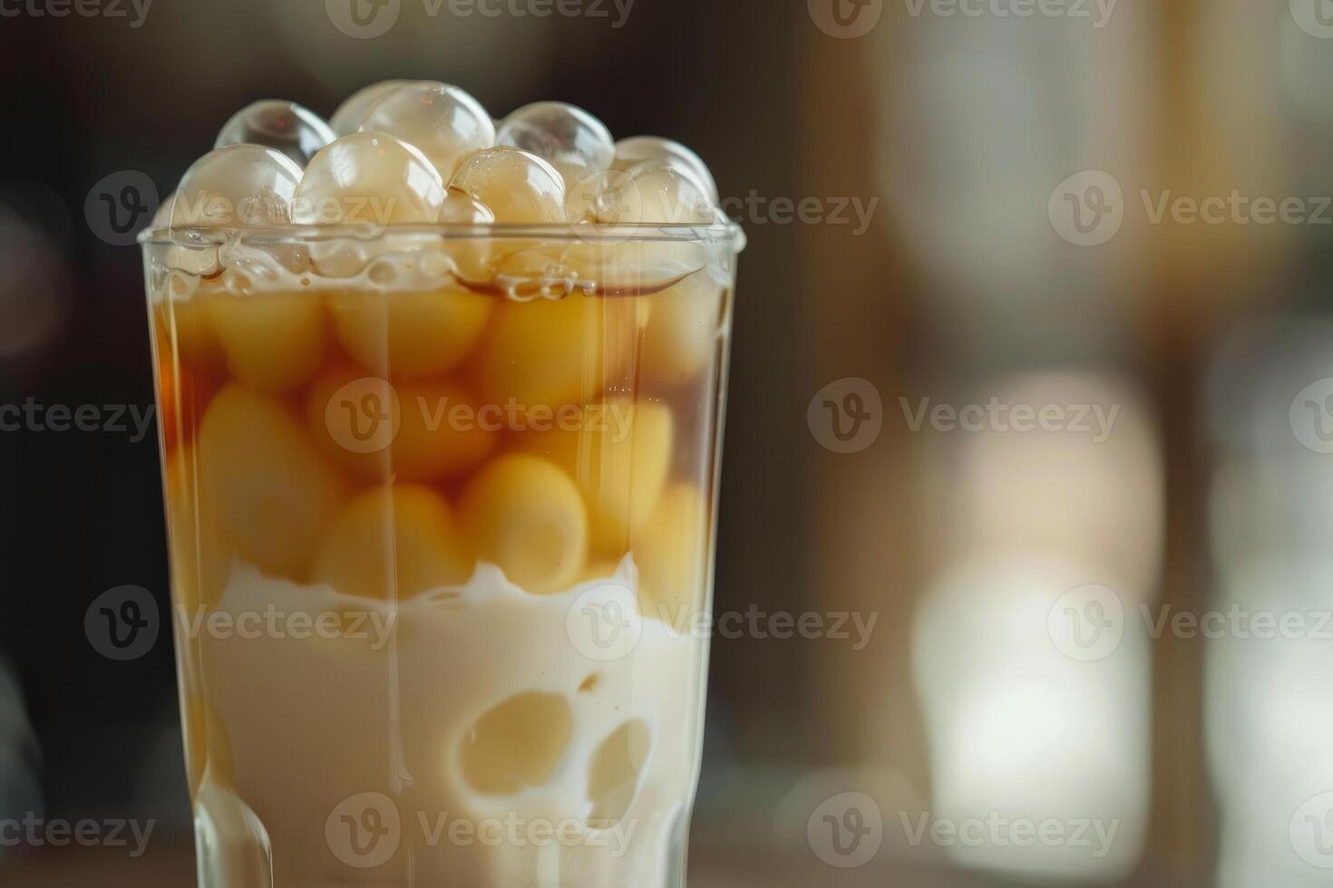 Glass of refreshing milk tea with boba and tapioca pearls being served in a cafe photo