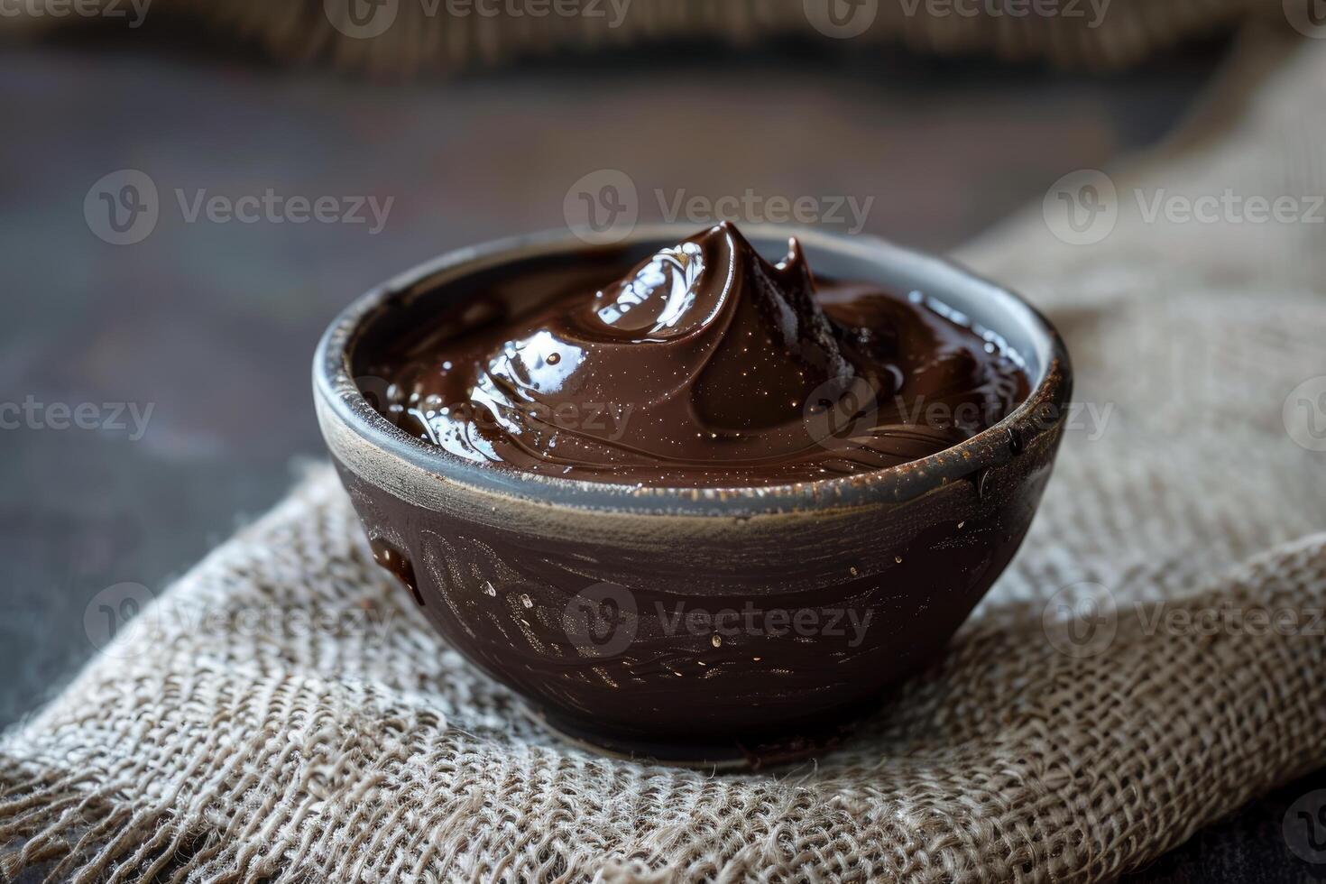 Bowl of delicious chocolate cream on rustic burlap is waiting for dessert photo