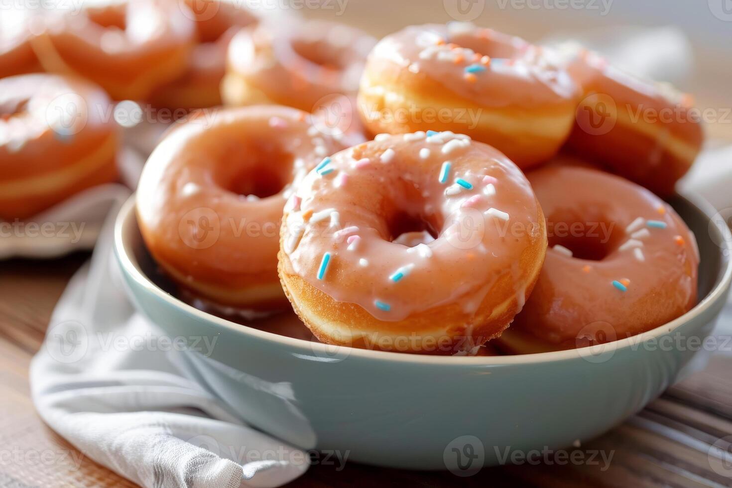 Delicious donuts with sprinkles resting in bowl on table photo