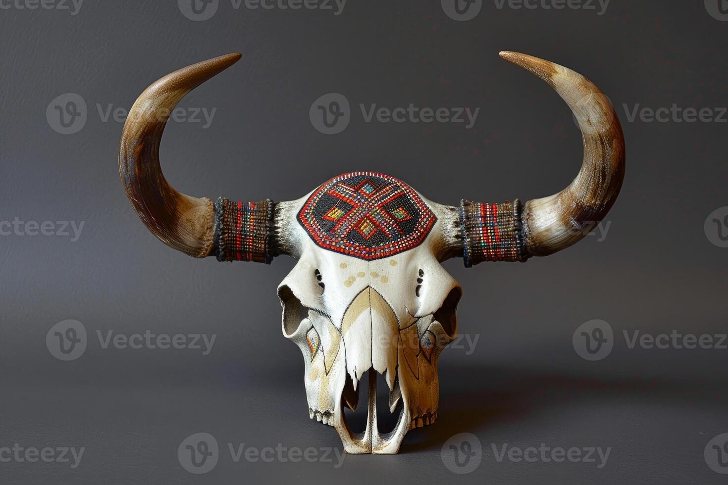 Decorated cow skull with horns and beads on gray background photo