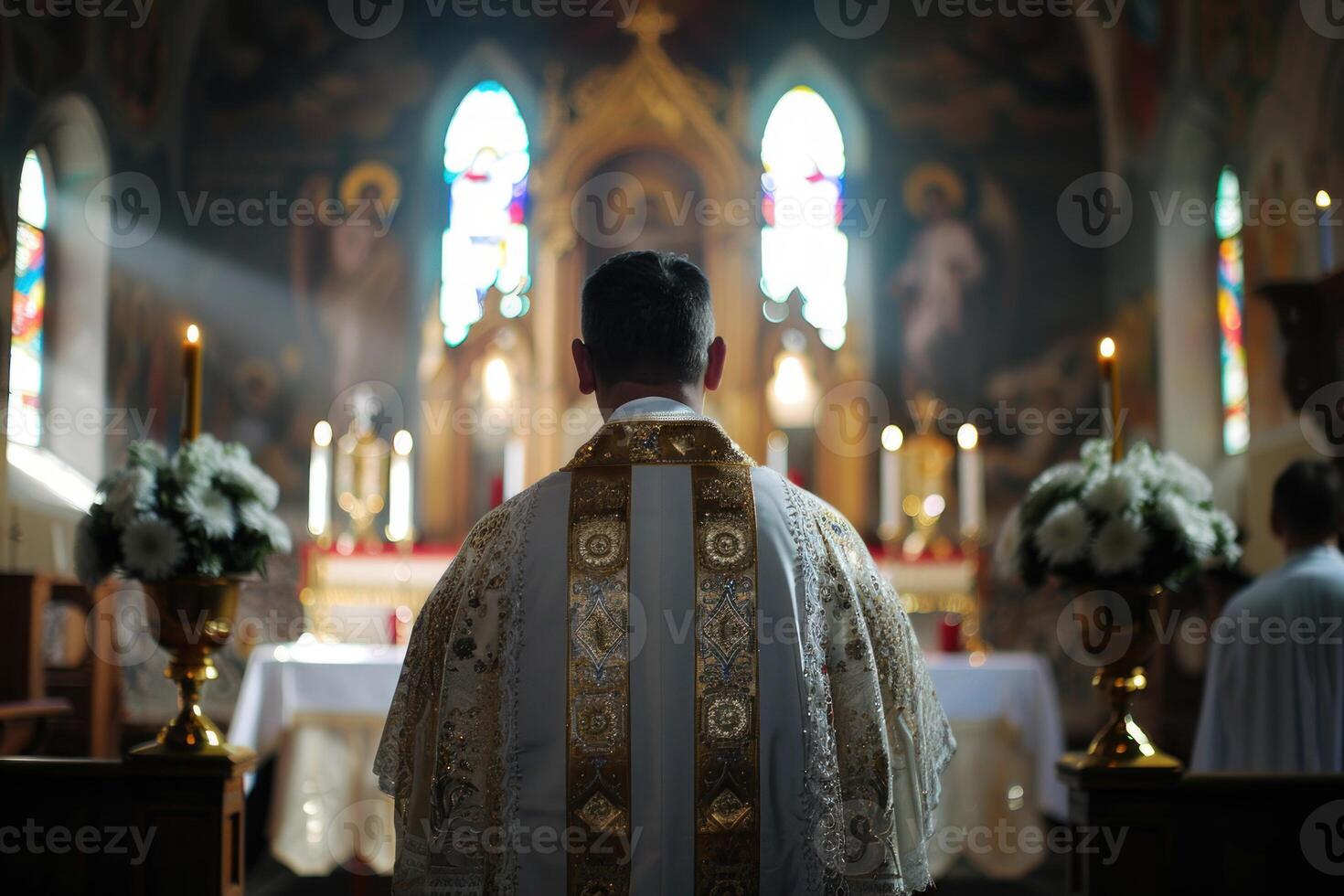 Catholic priest wearing gold robe praying in church photo