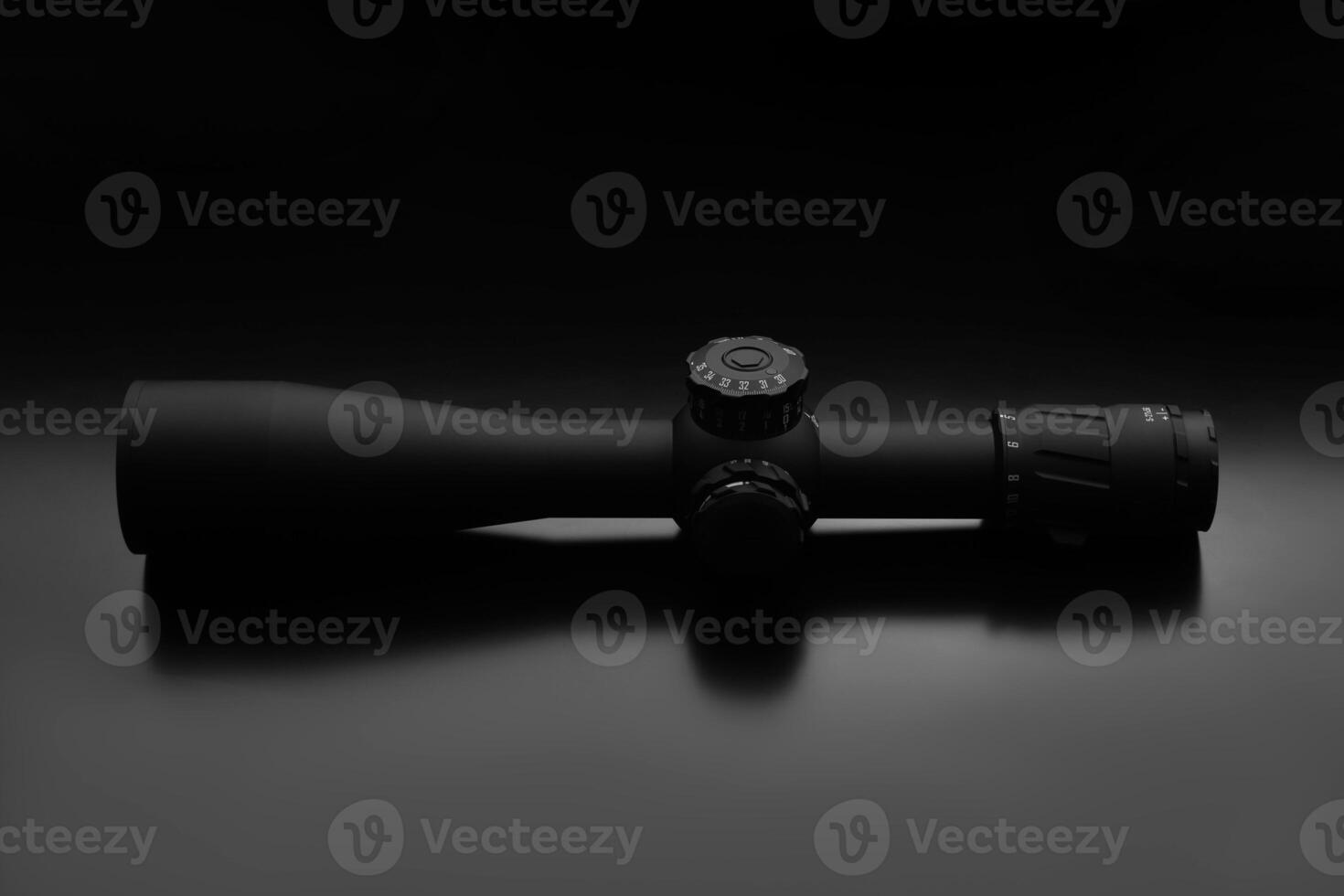 Modern sniper scope on a dark back. Optical device for aiming and shooting at long distances. photo