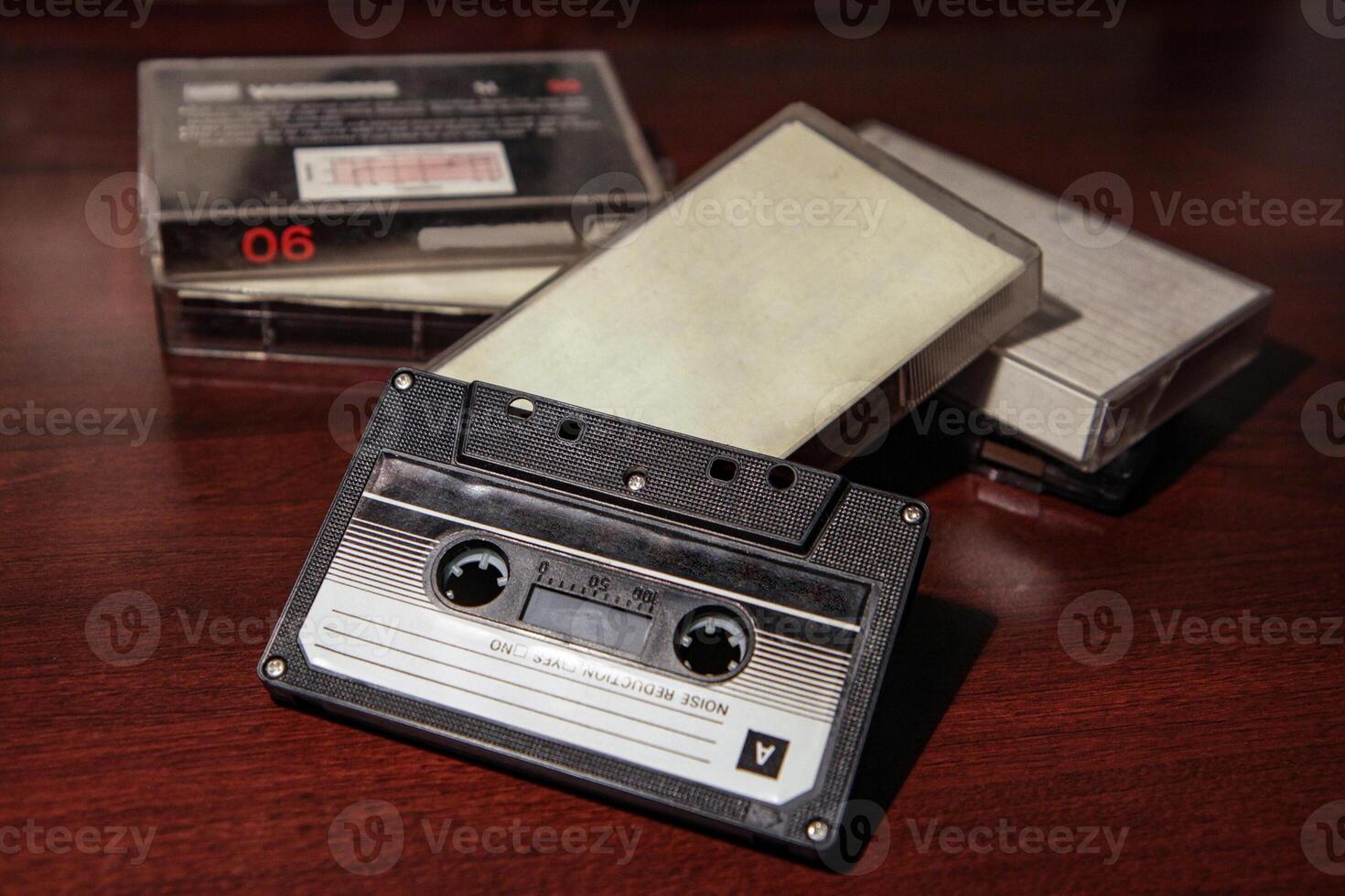 Blank cassette tape box on old wooden table background. Vintage cassette tape case with retro cassette mockup. Mixtape box cover. Plastic analog magnetic clear packaging template. photo