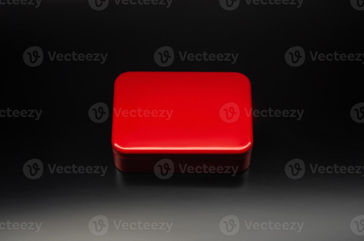 Red metal box of a rectangular background on a black gradient background. Mockup of bright packaging for a small gift. Dark back. photo